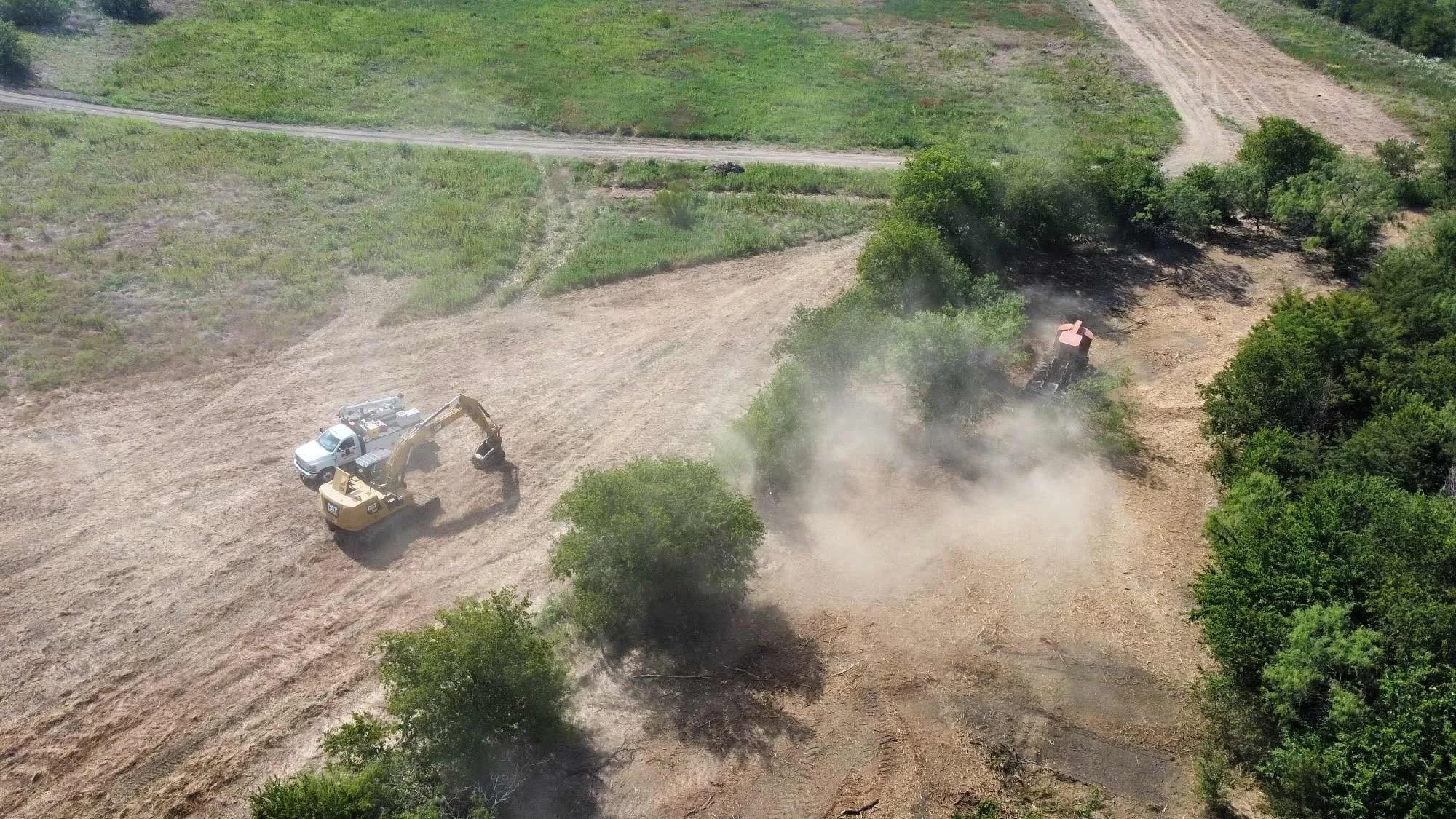 An overhead view of heavy equipment clearing a rural tract of land ahead of construction