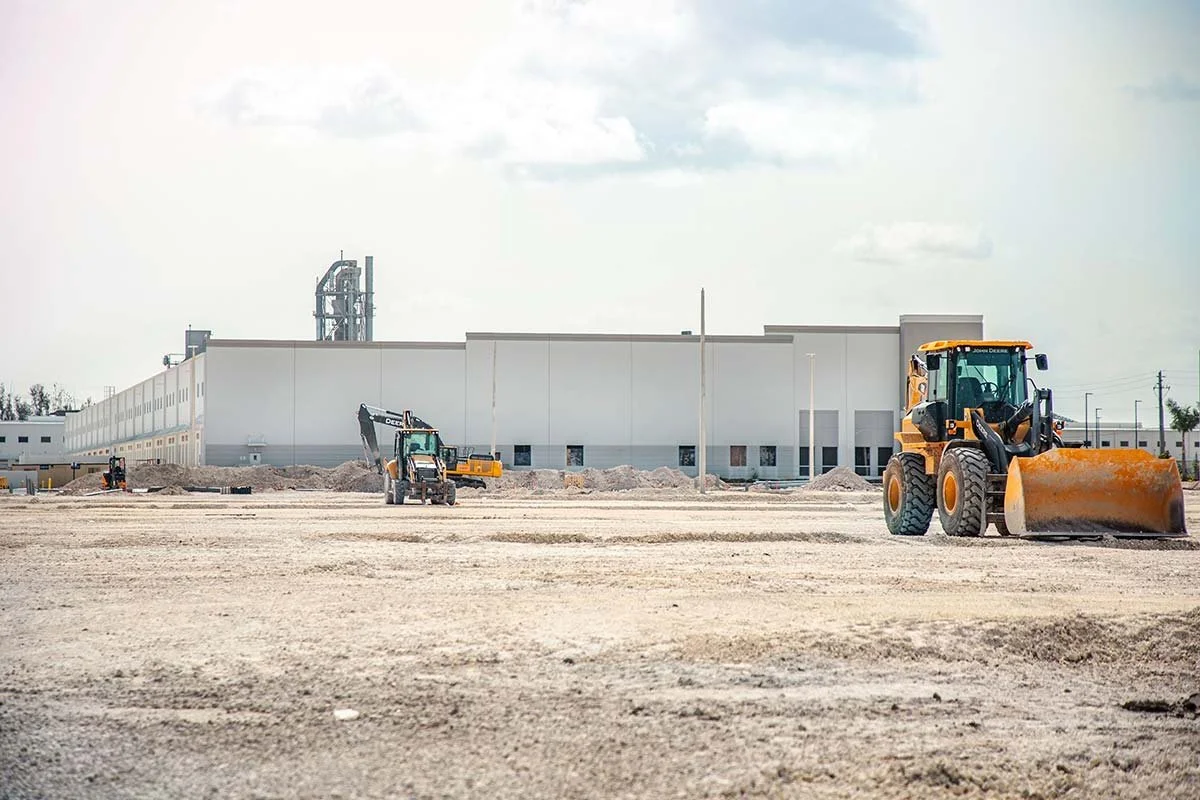 Heavy equipment in a lot being cleared on an industrial development site