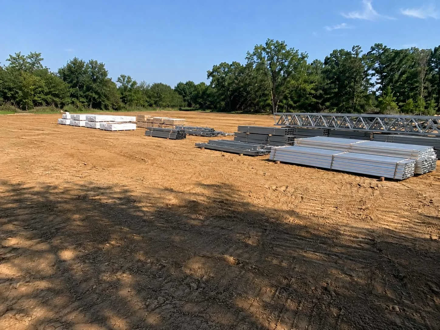 A freshly cleared rural lot with metal building construction materials