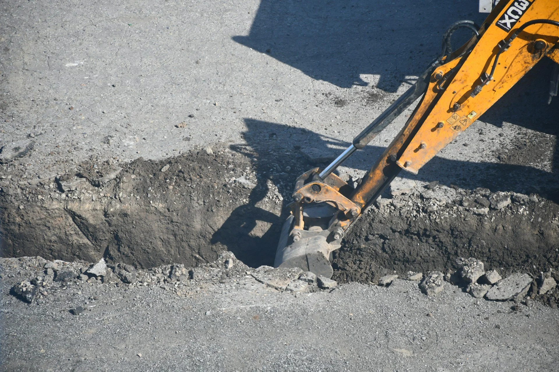 Excavator digging a drainage trench on a construction site
