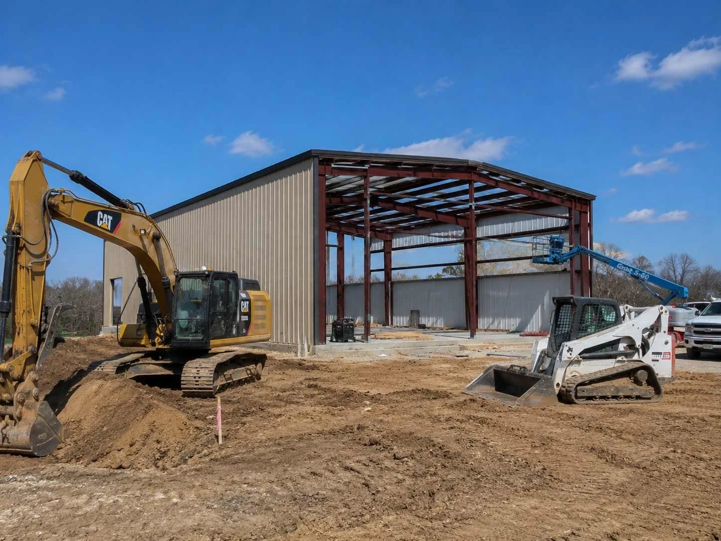 Heavy land clearing equipment and a metal building mid-construction