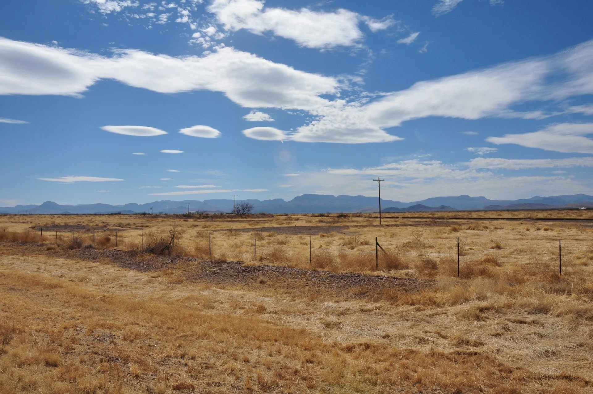 Rural Texas land under a blue, partially cloudy sky
