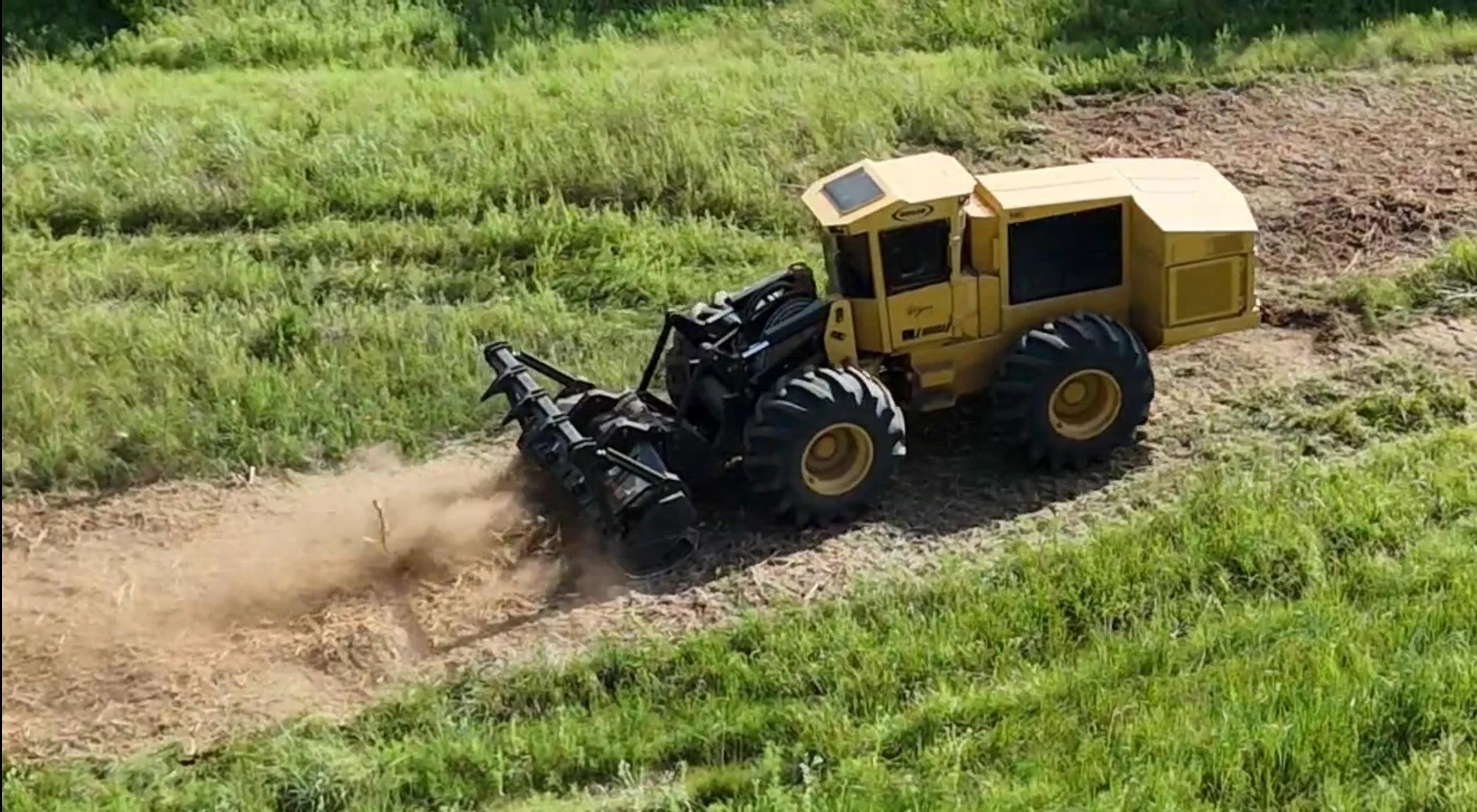 Large yellow land clearing machinery in operation
