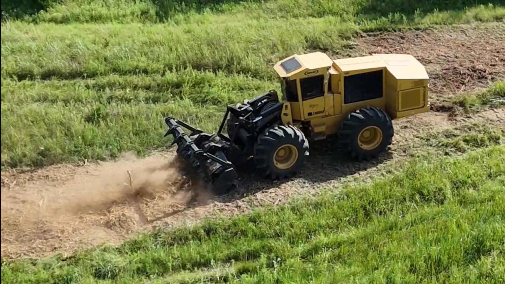 Large yellow land clearing machinery in operation