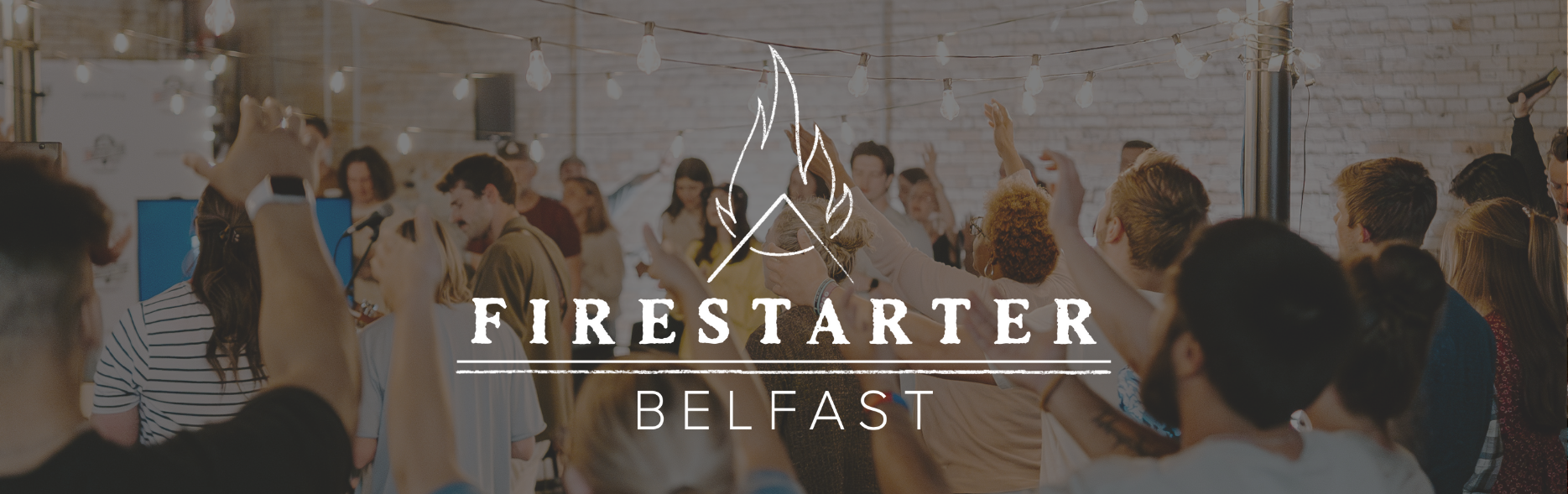 Firestarter Belfast logo sits atop a photo of diverse group of people lifting their hands to worship.