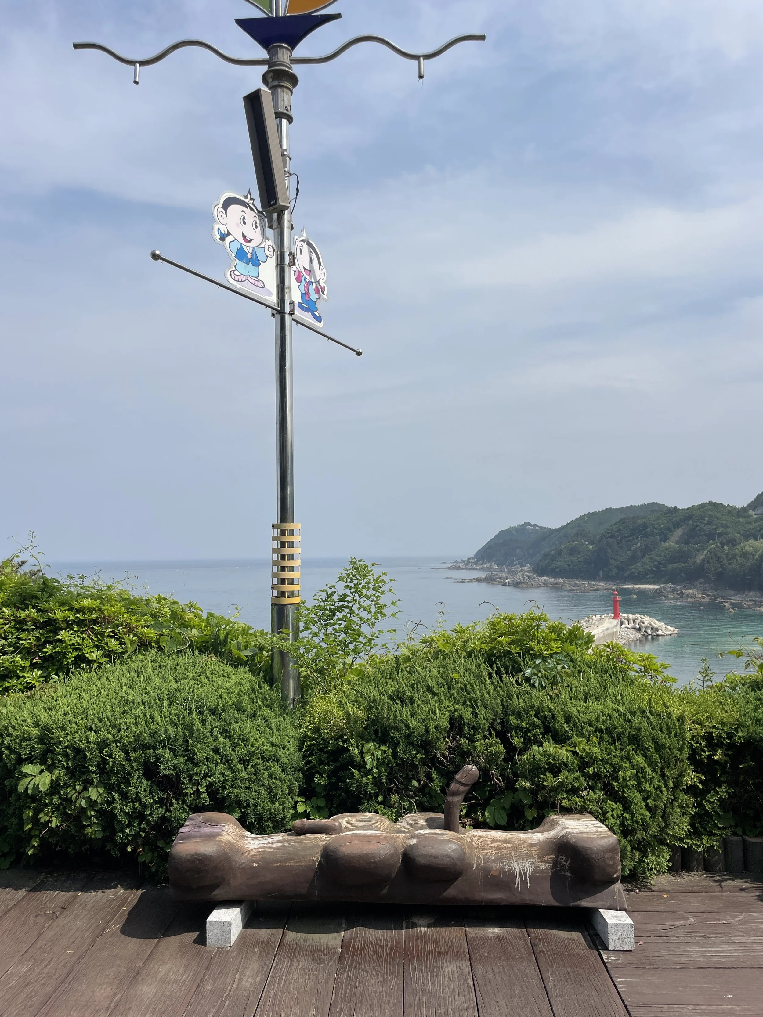 Wooden phallic sculpture overlooking the sea at Haesindang Park in South Korea