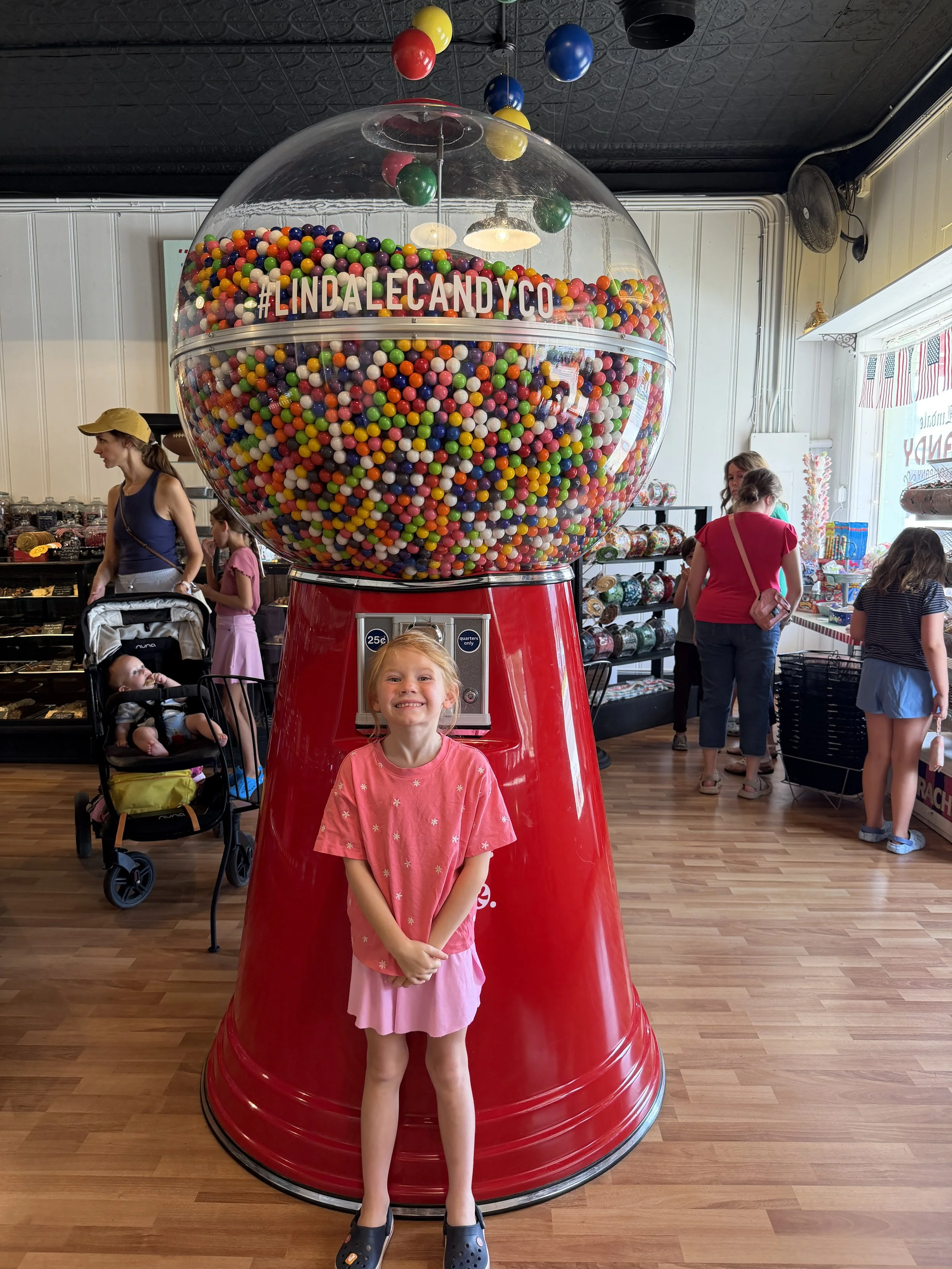 millie with the giant gumball machine at lindale candy co.JPG