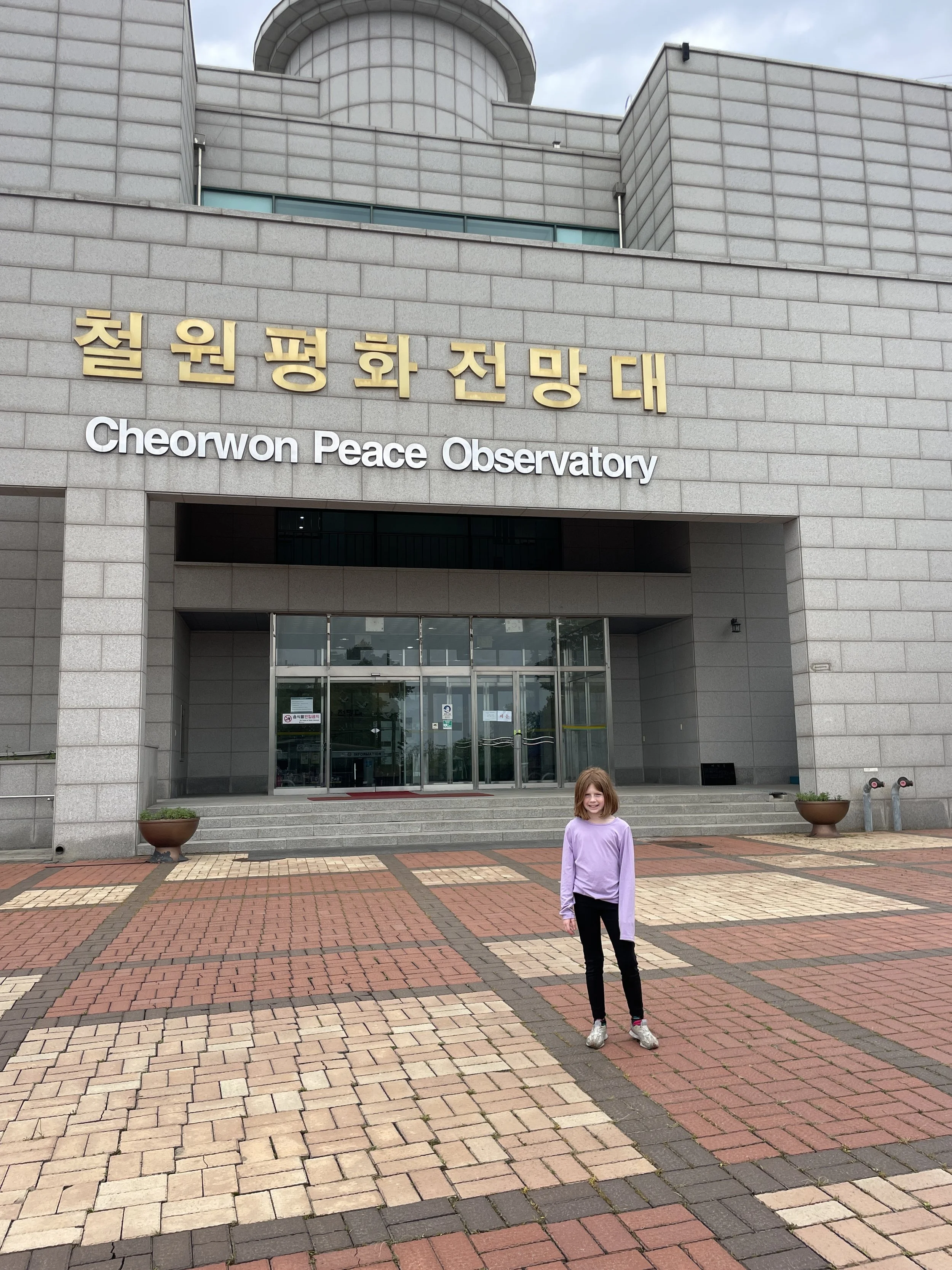 child standing outside of cheorwon peace observatory.JPG