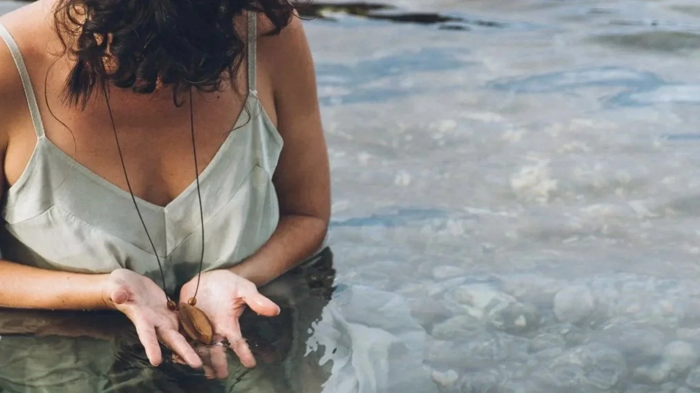 Mano que roza el agua del mar en la costa de Tenerife