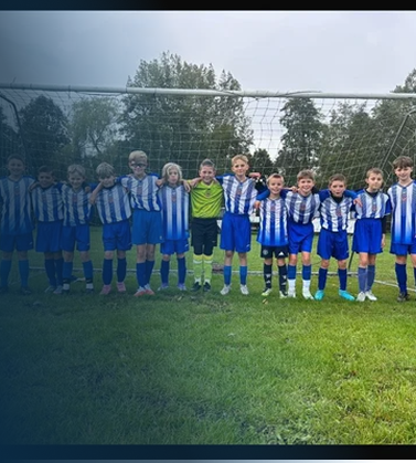 Youth soccer team standing in a line on a soccer field