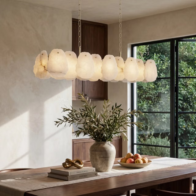 Alba Alabaster Island Pendant by MOD Lighting, featuring a sculptural row of softly illuminated natural alabaster forms suspended above a dining table.