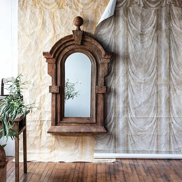 Antiqued Dormer Mirror, through Antique Farmhouse. An arched iron frame, weathered finish, and generous scale bring architectural depth and antique-inspired character to a collected interior.