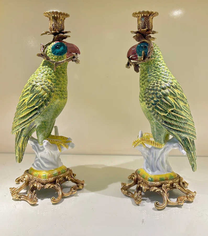 Green Parrot Candelabra by HomeDor. Porcelain birds and ornate brass details bring vibrant color, sculptural charm, and Hollywood Regency-inspired glamour to a collected interior.