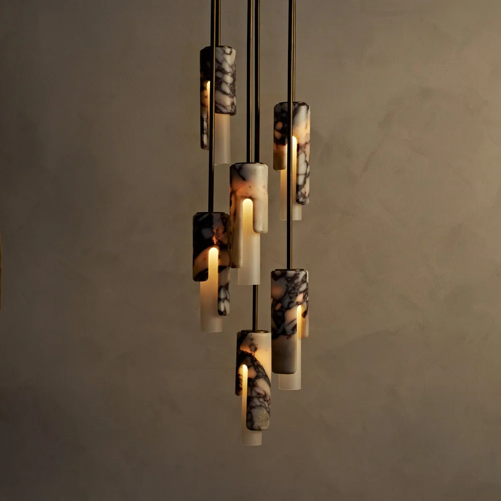 Dover Chandelier by Studio Luddite, featuring staggered carved stone pendants in Calacatta Viola with blackened brass.