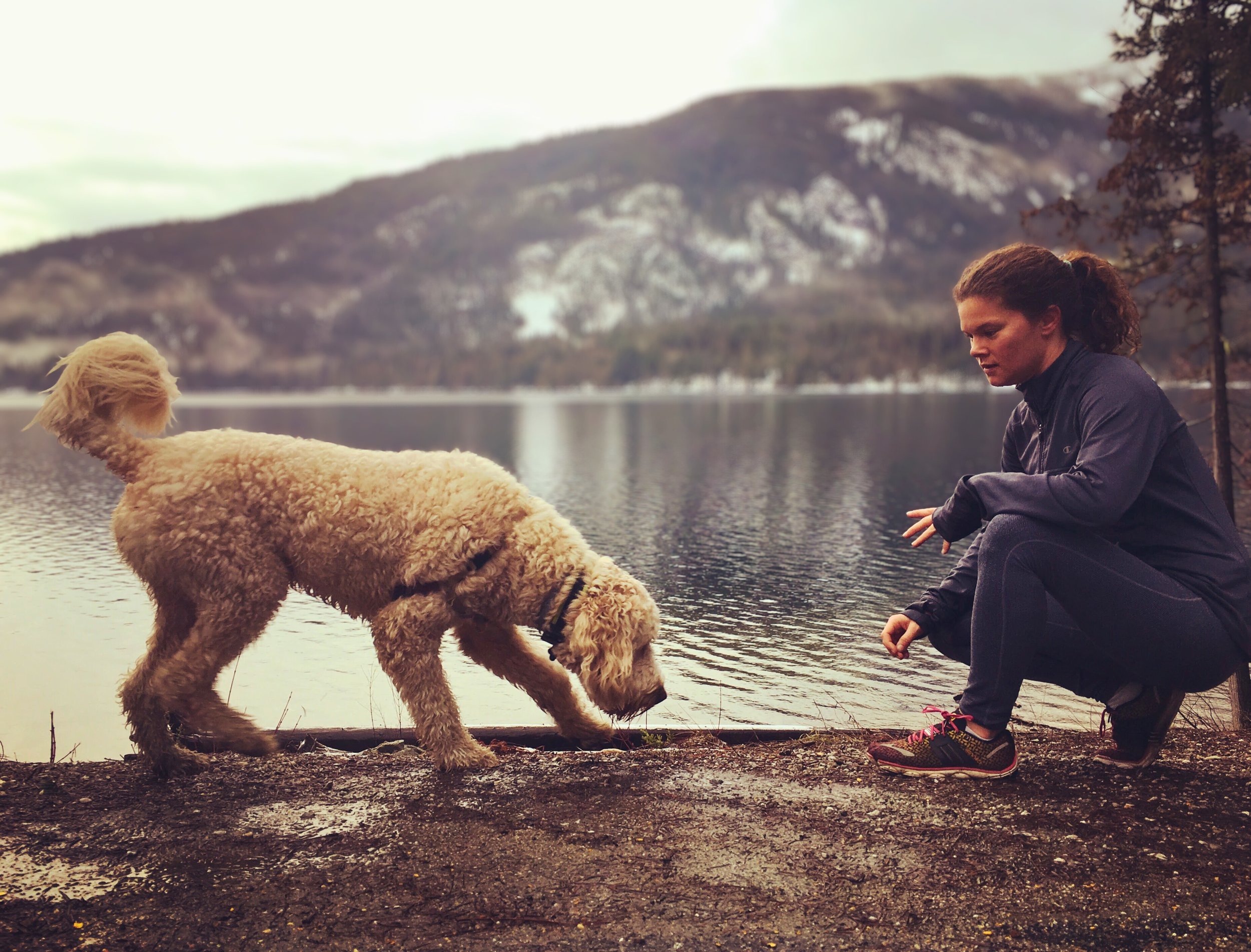 Picture of Lindsay and her dog in front of a mountain lake