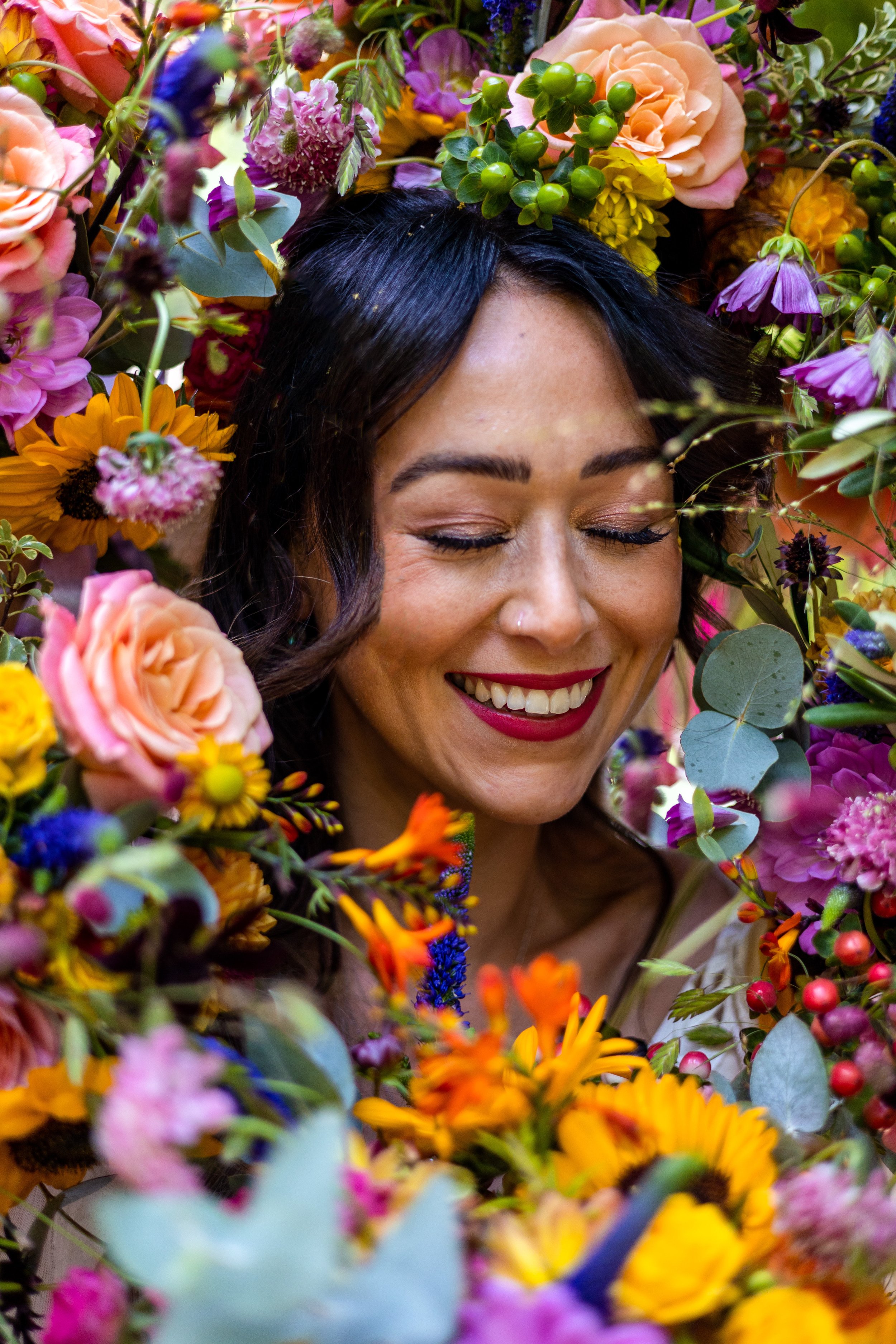 bride surrounded by colourful bridesmaid bouquets as in the tiktok trend for alternative wedding portraits