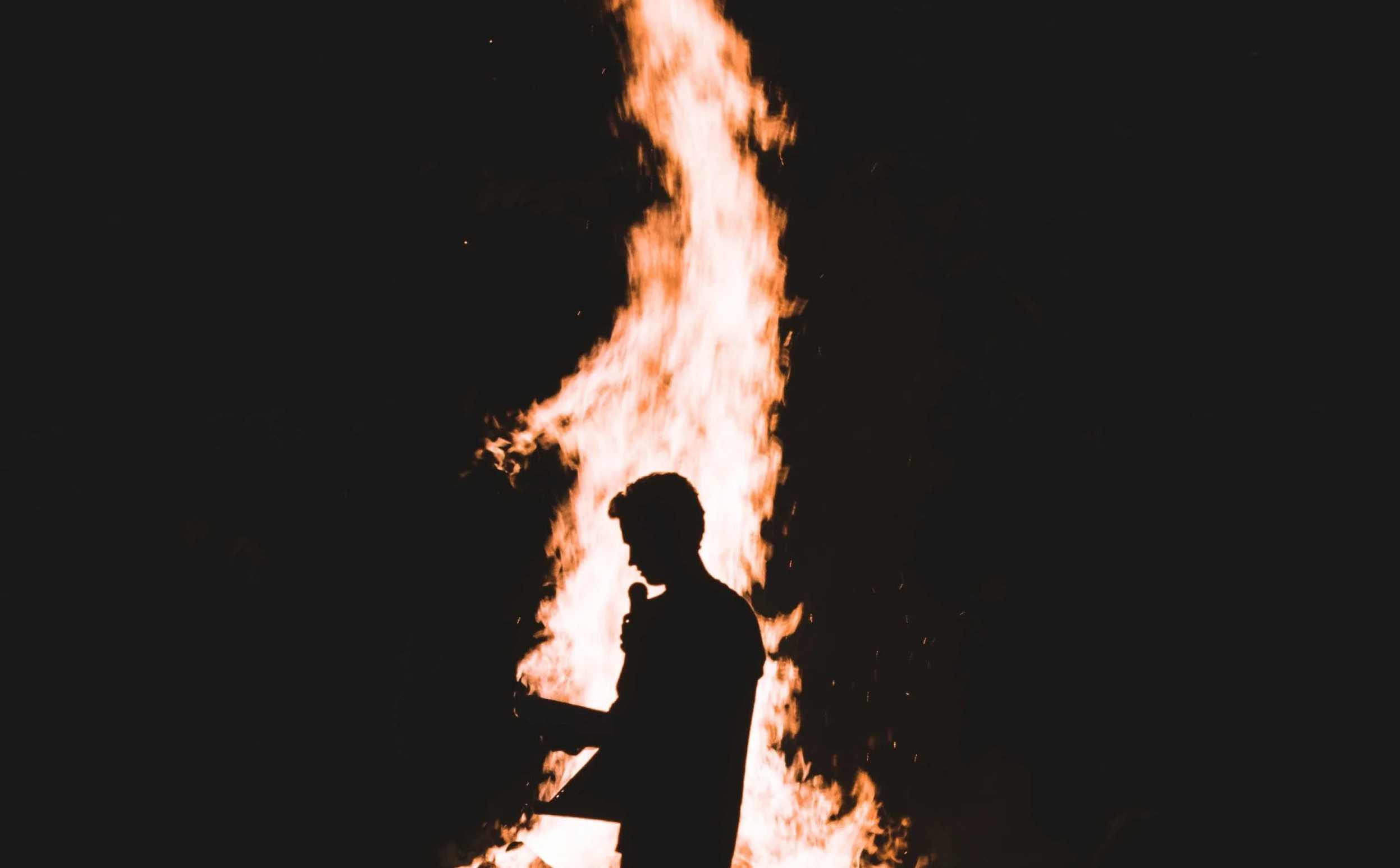 Silhouette of a Man with a Microphone Engulfed in Flames