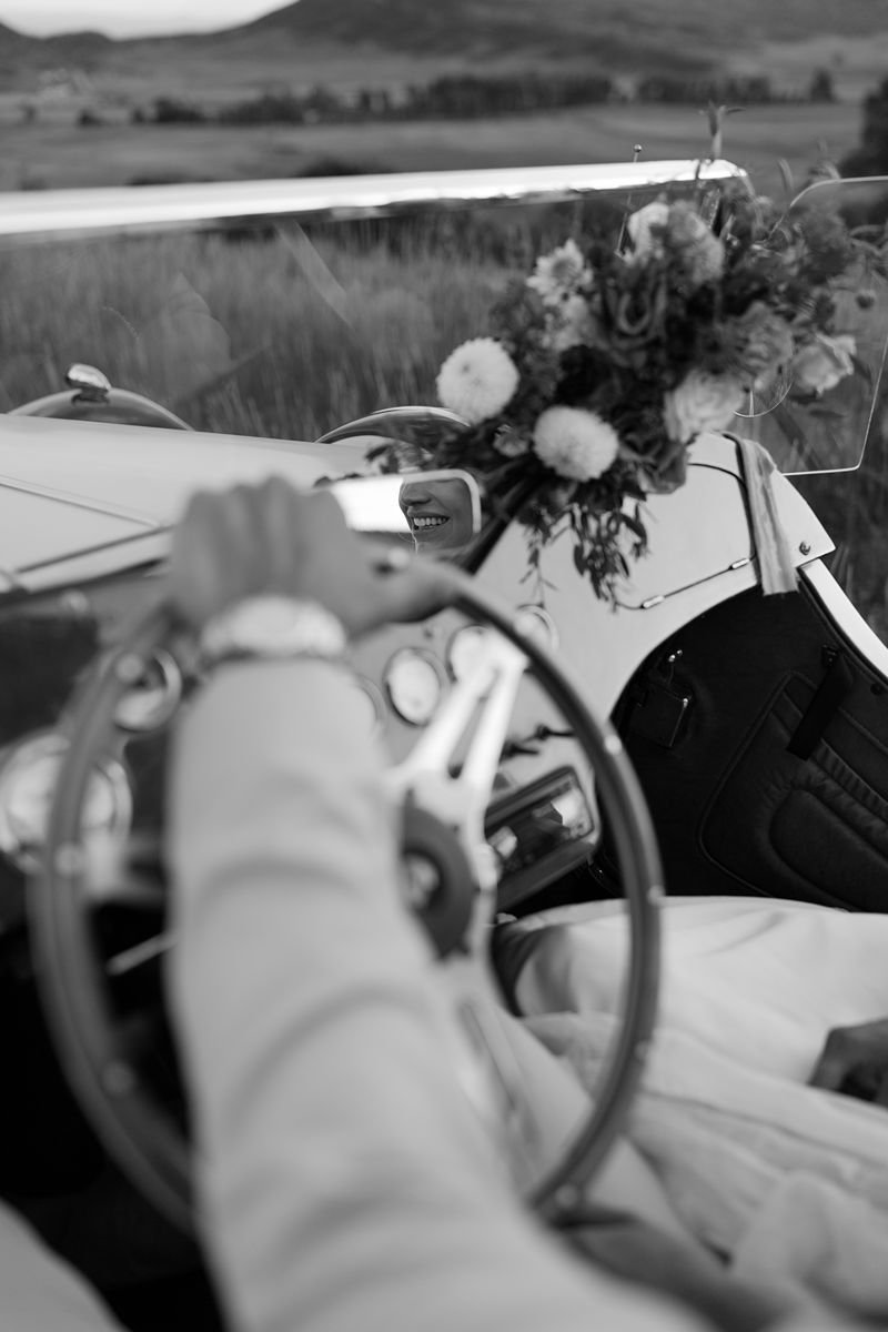  Groom’s hand on steering wheel with vintage car at La Joya Dulce Steamboat Springs 