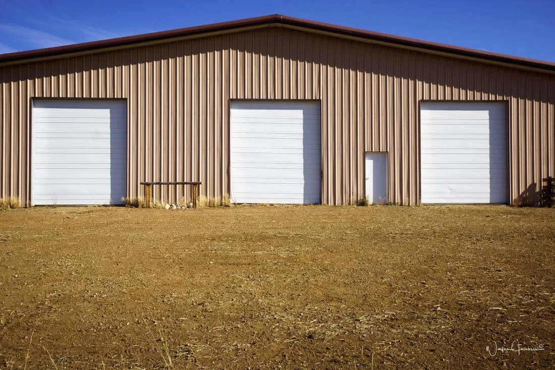 Dirt for ceremony site before grass and plain white garage doors. All before the transformation for luxury wedding venue near Denver