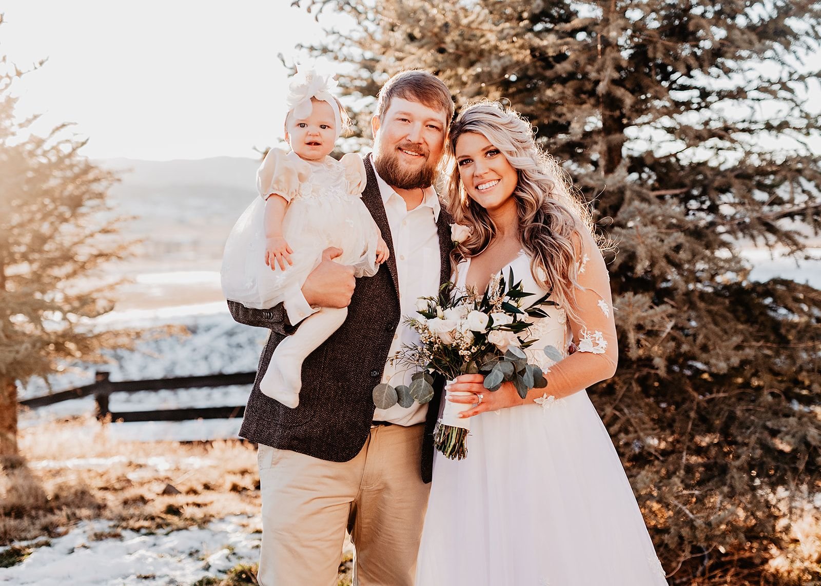 Bride and groom holding their baby during their winter wedding at La Joya Dulce in Steamboat Springs, Colorado