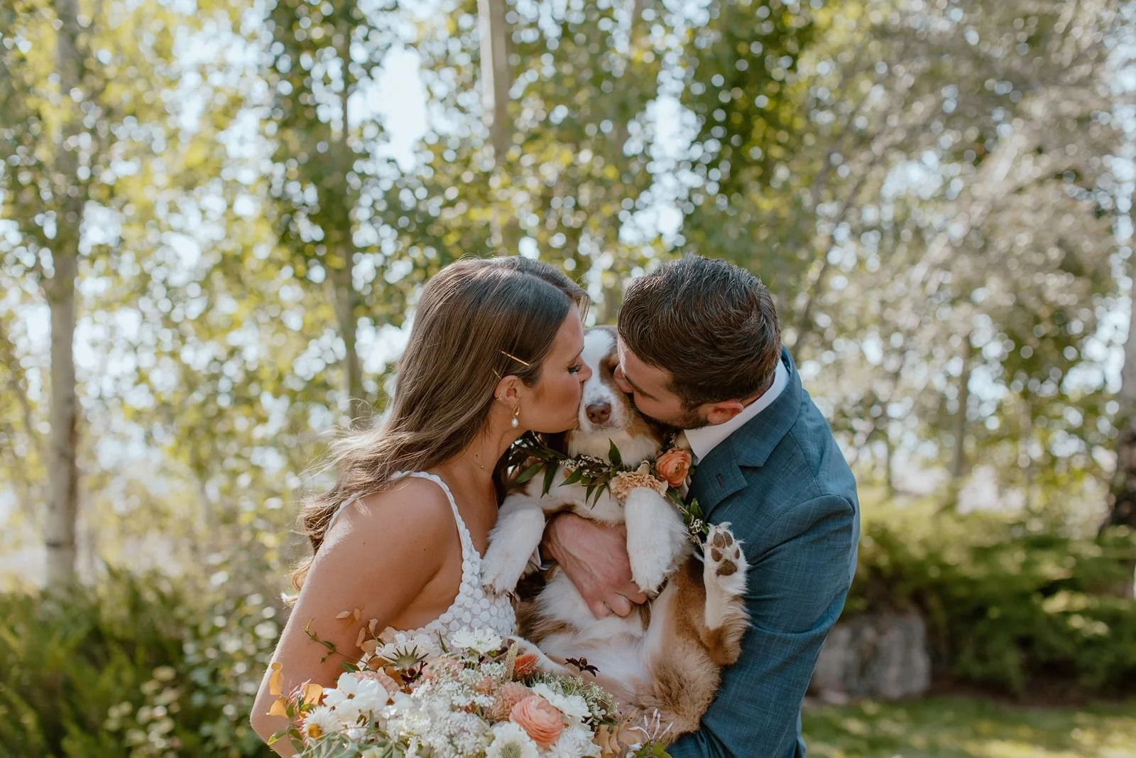 Couple kissing their dog before ceremony at destination ranch wedding venue in Steamboat Springs