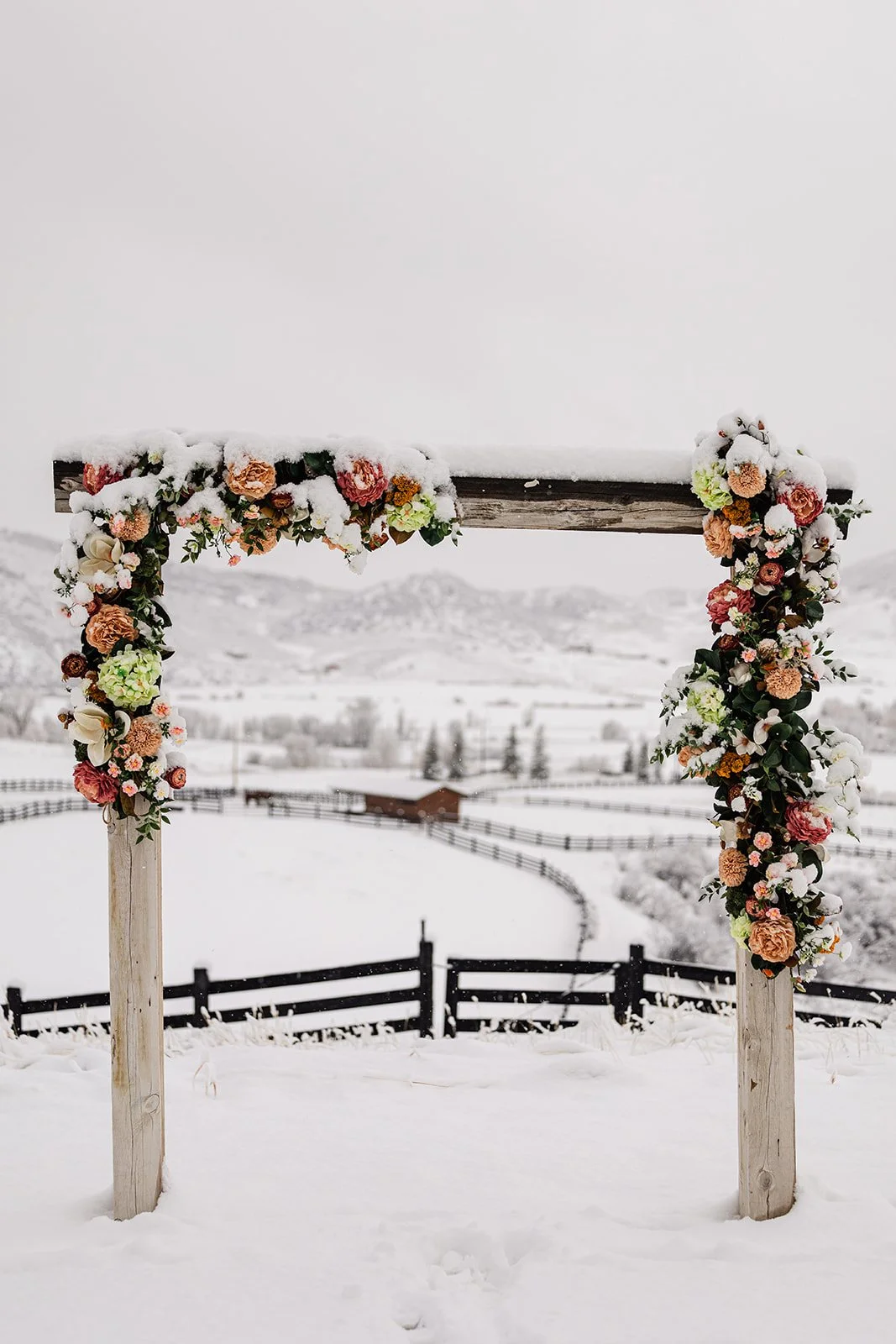 Floral and snow covered arch for luxury winter wedding at ranch in Steamboat Springs