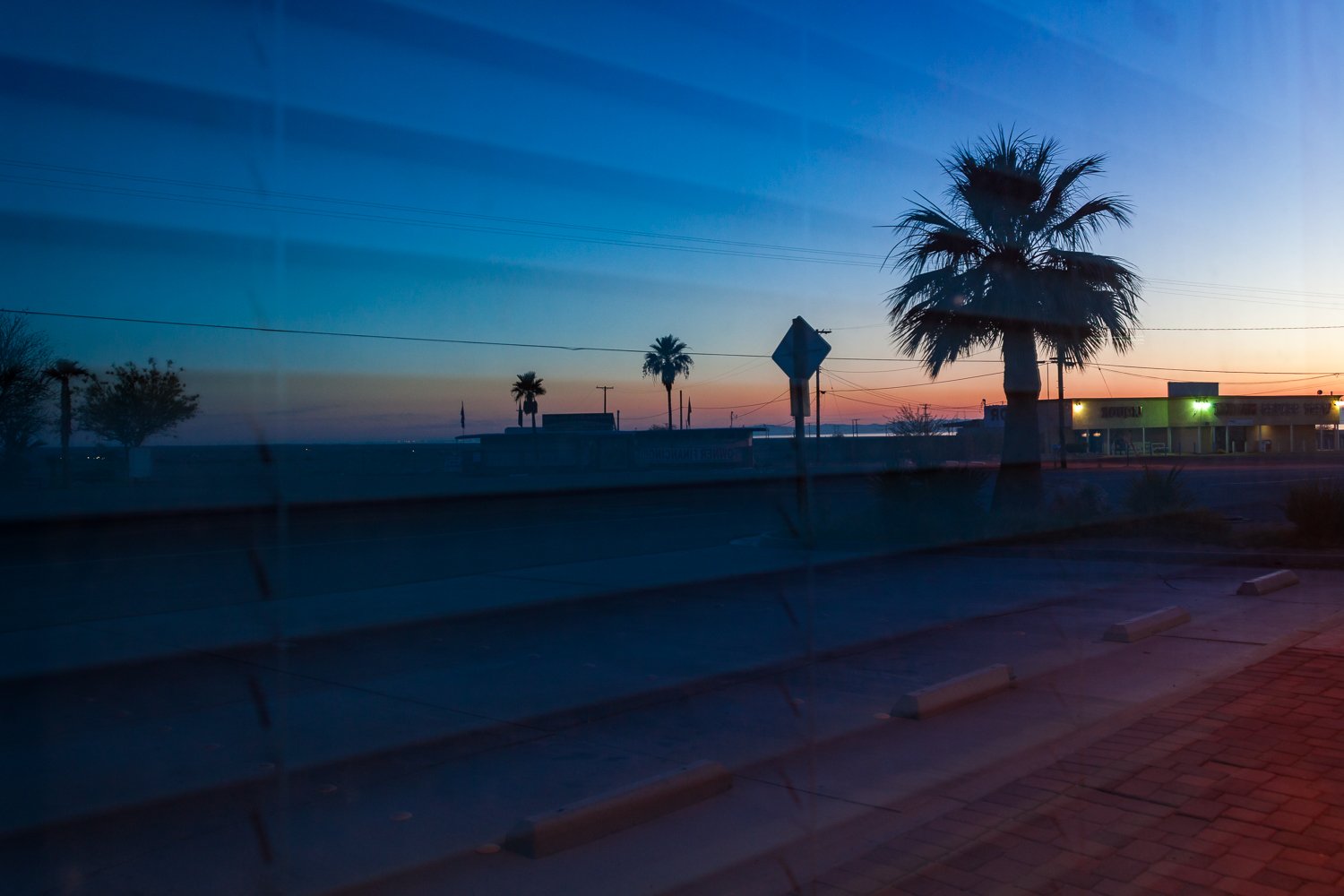 Sunrise over the empty streets is reflected in a local abandoned storefront in the Salton Sea, California.