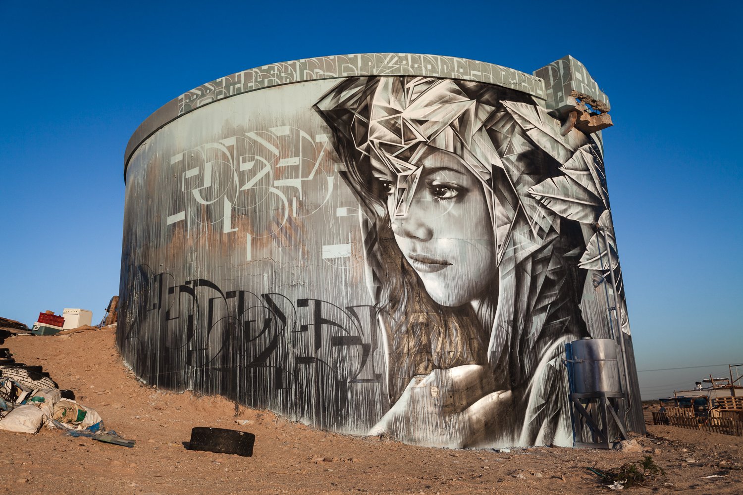 Street art covers an abandoned water tower.