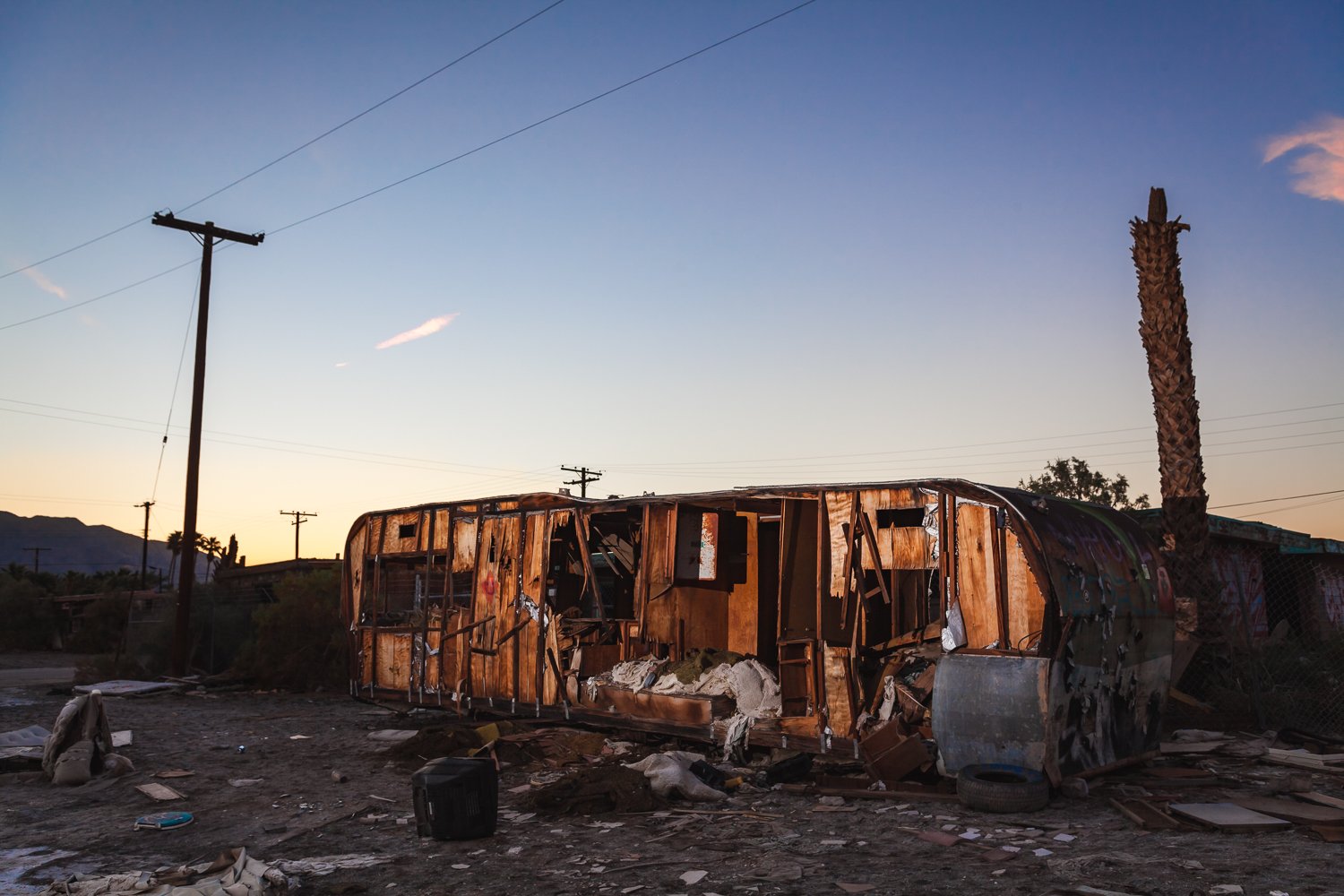 The cutting wind of the desert has dissected a trailer home, exposing its contents.