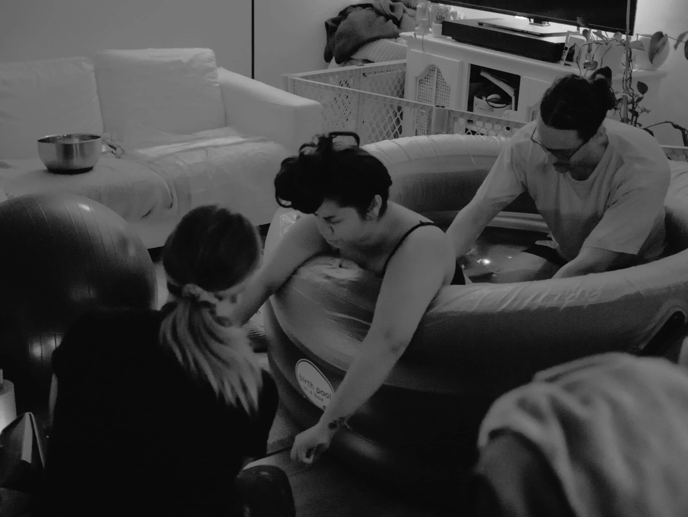 A birth doula with The Breezy Doula assists in a water birth in San Diego, CA.