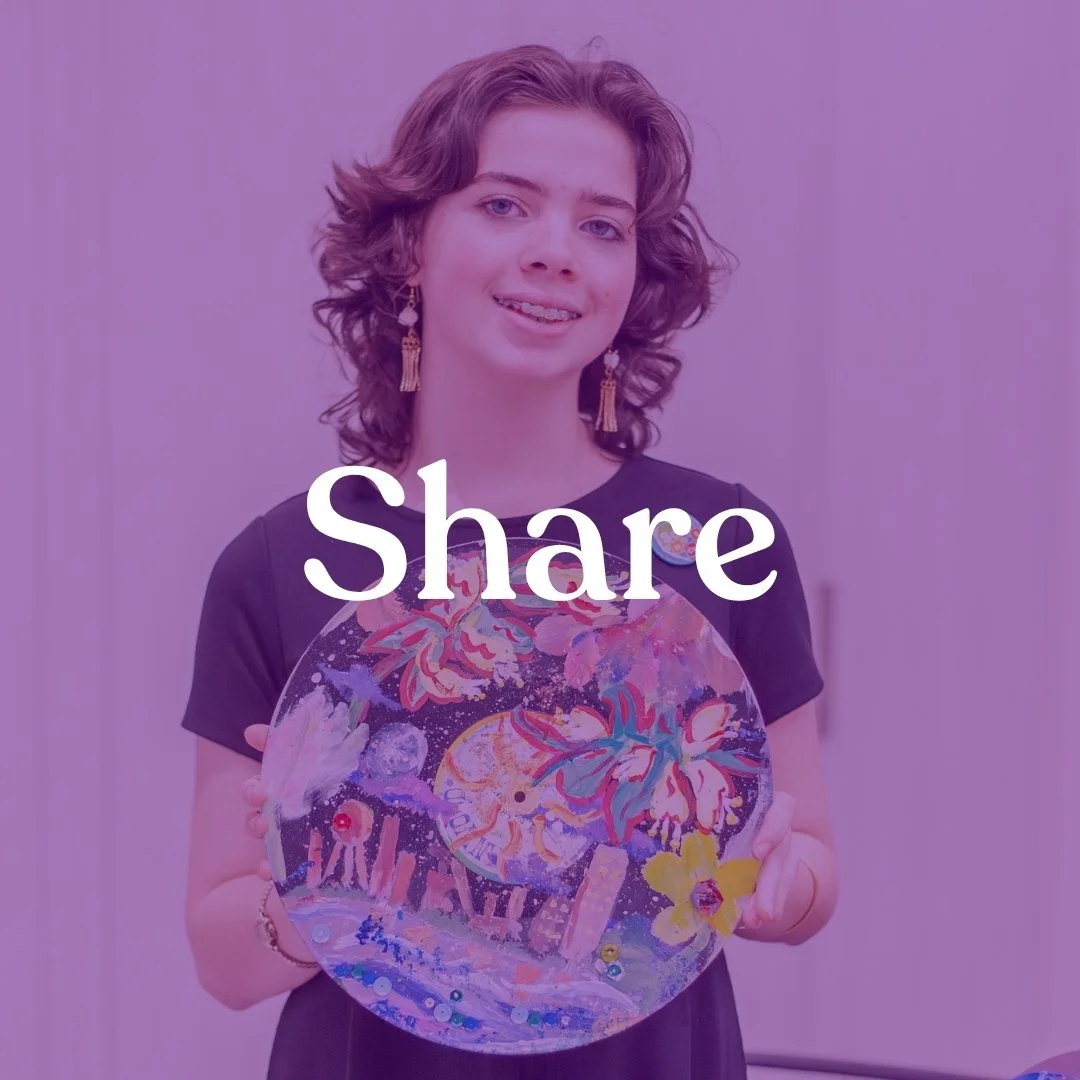 A woman with curly brown hair holding a colorful, flower-themed glass plate, standing against a plain background.