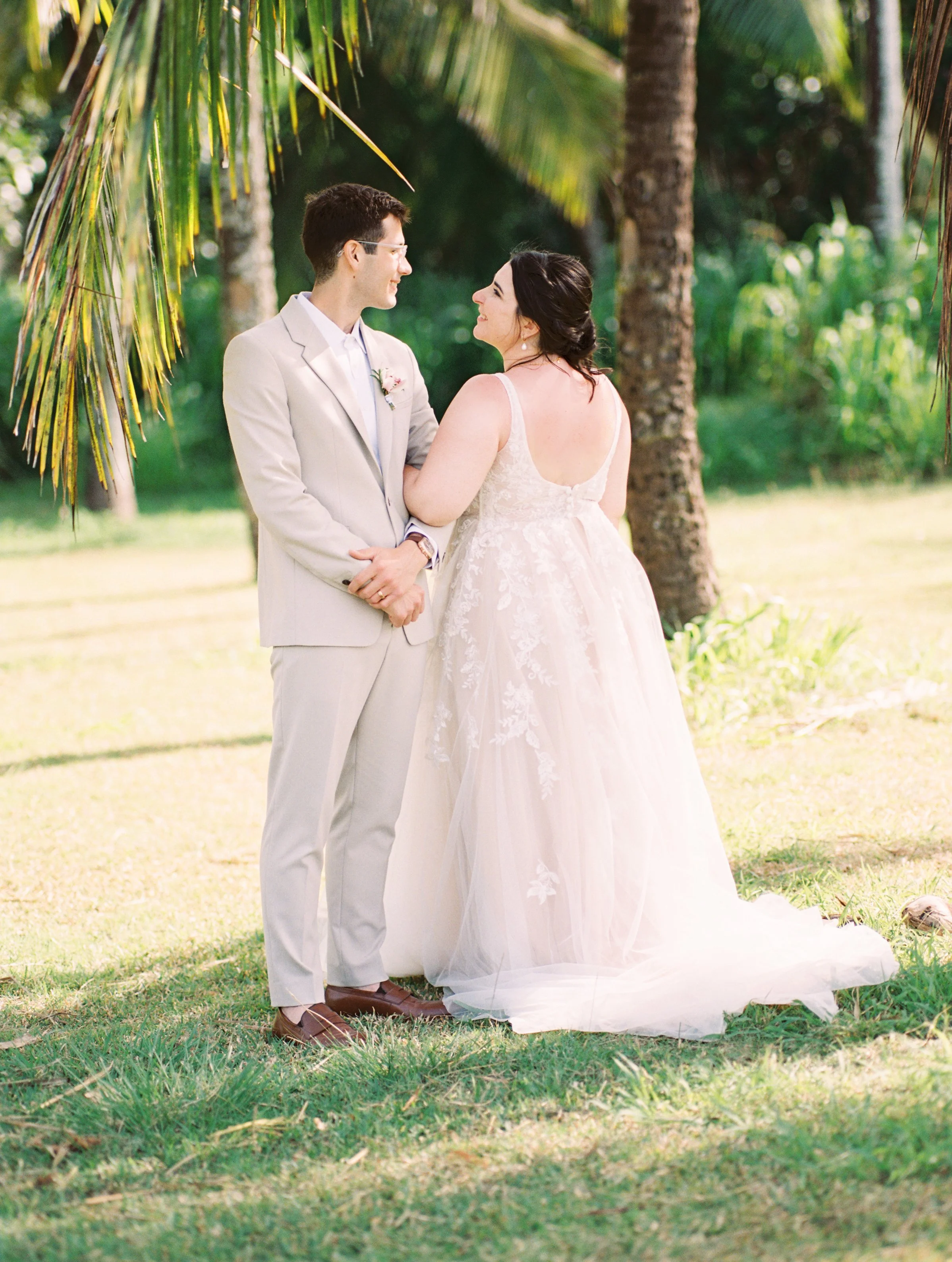 Couple standing under tropical palm trees for a Maui adventure elopement