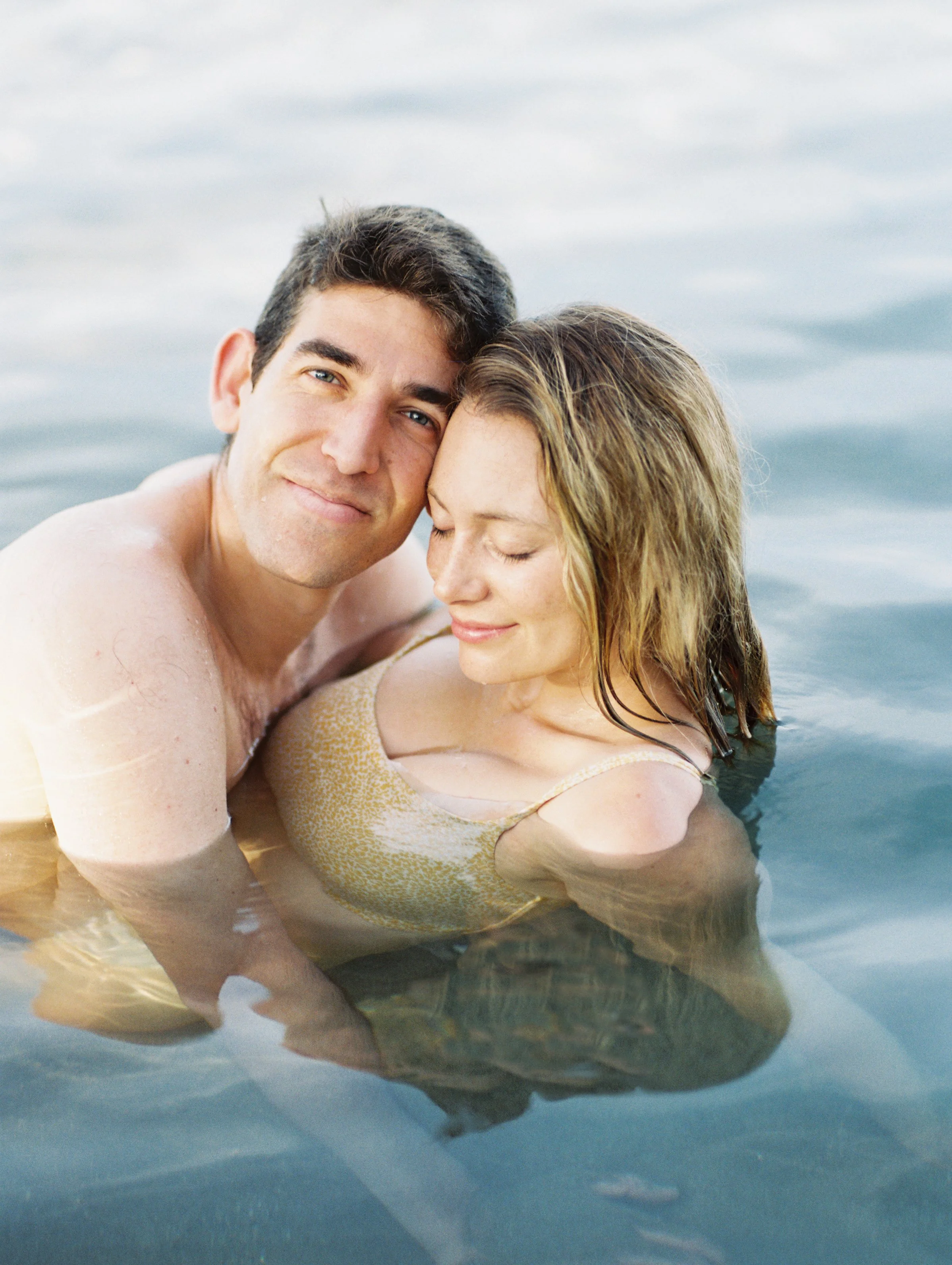 A couple in the ocean during a film photoshoot in Lahaina Maui.