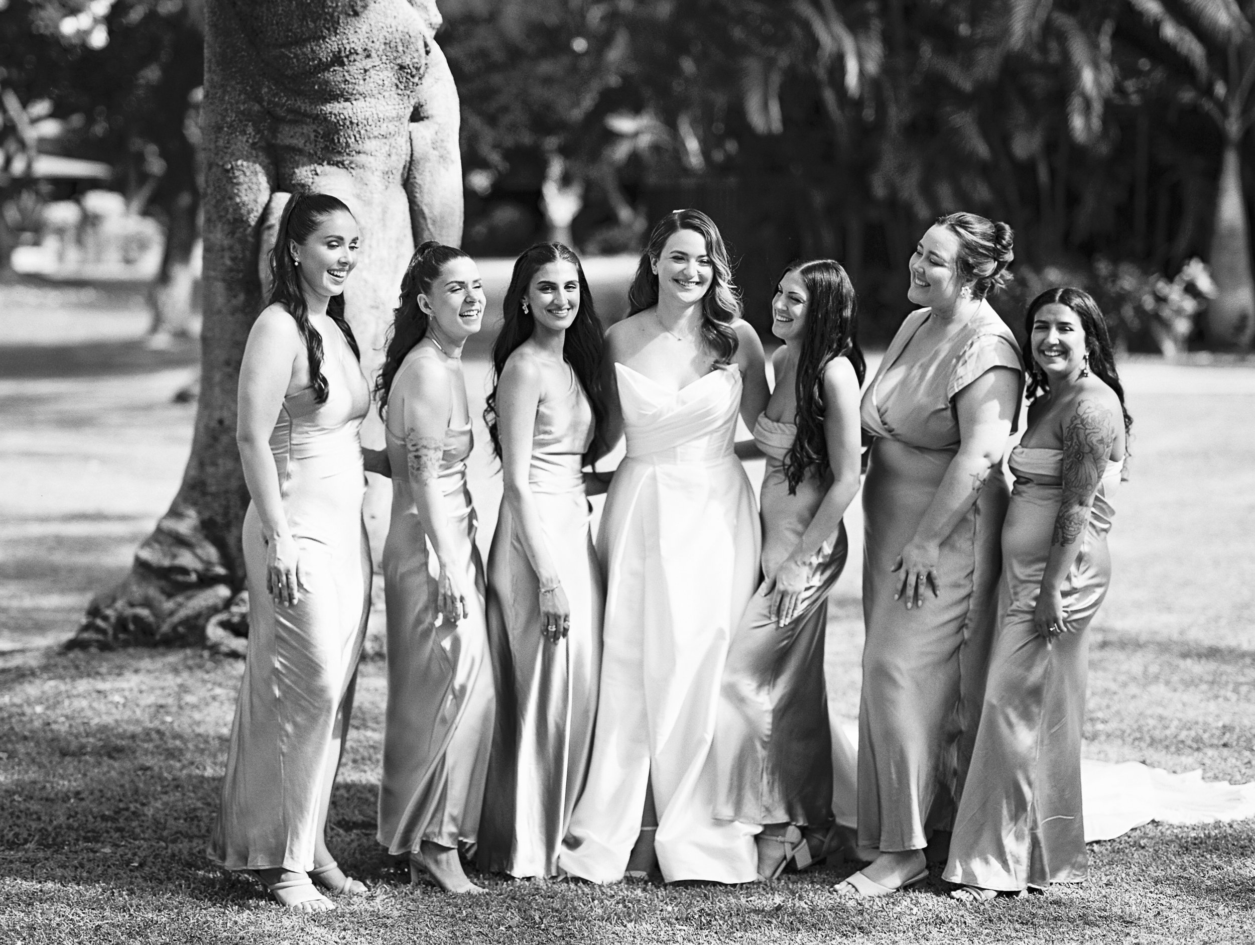 A bride and her bridesmaids laughing on a lawn at The Royal Lahaina in Maui 