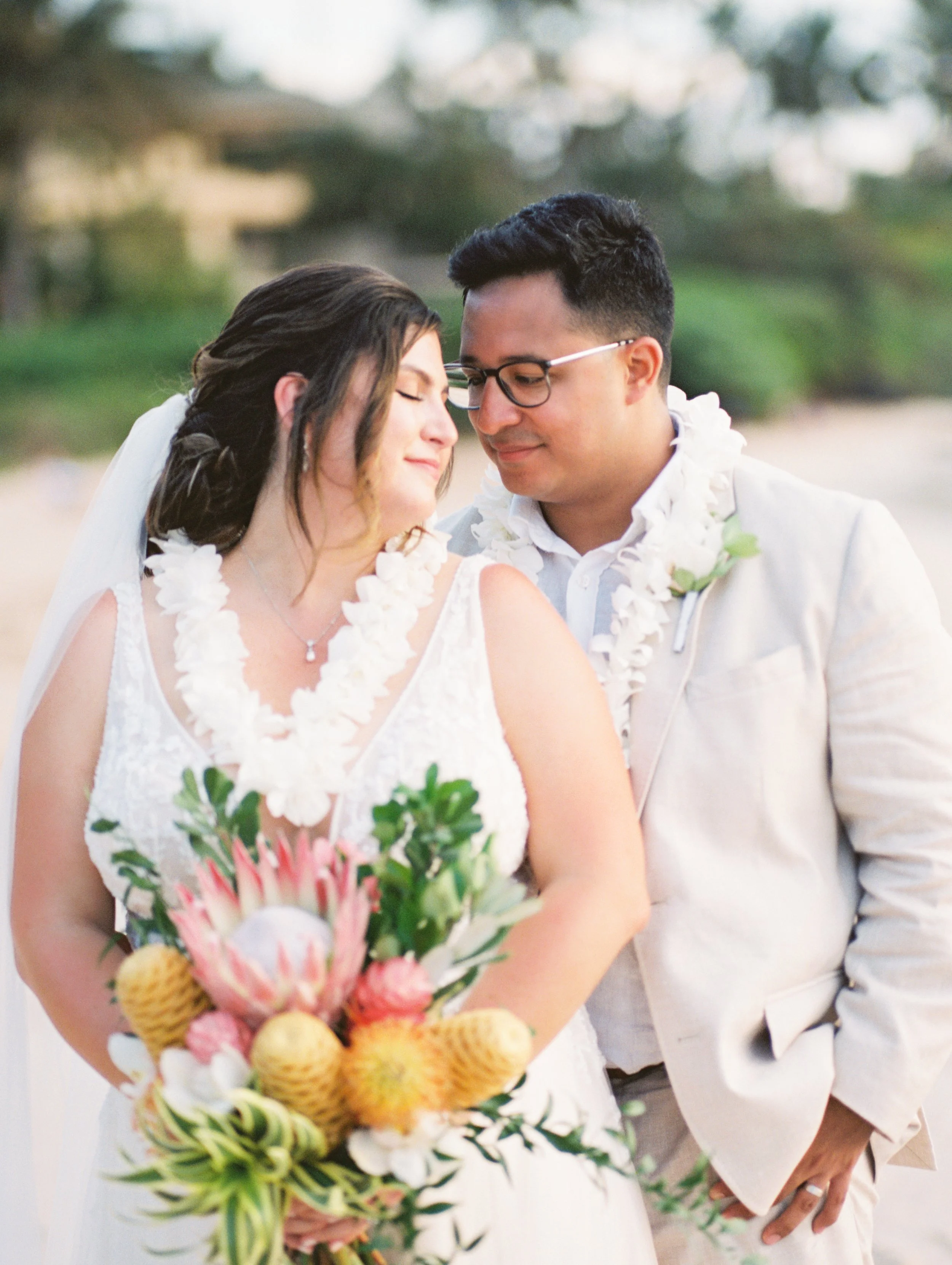 A bride and groom on a beach in Wailea Maui during sunset for their wedding portraits captured on film