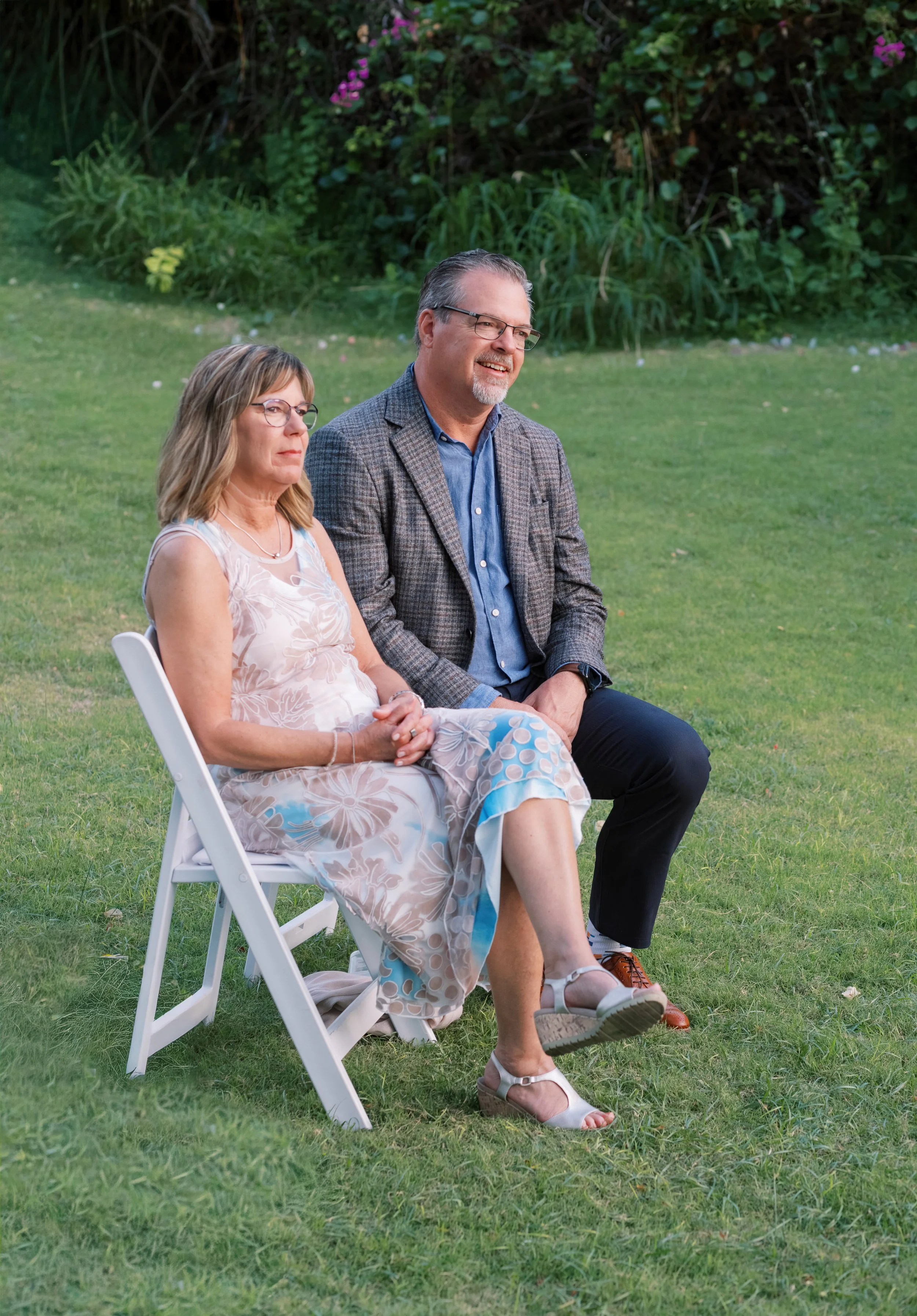 Grooms parents at Gather on Wailea smiling at the wedding couple