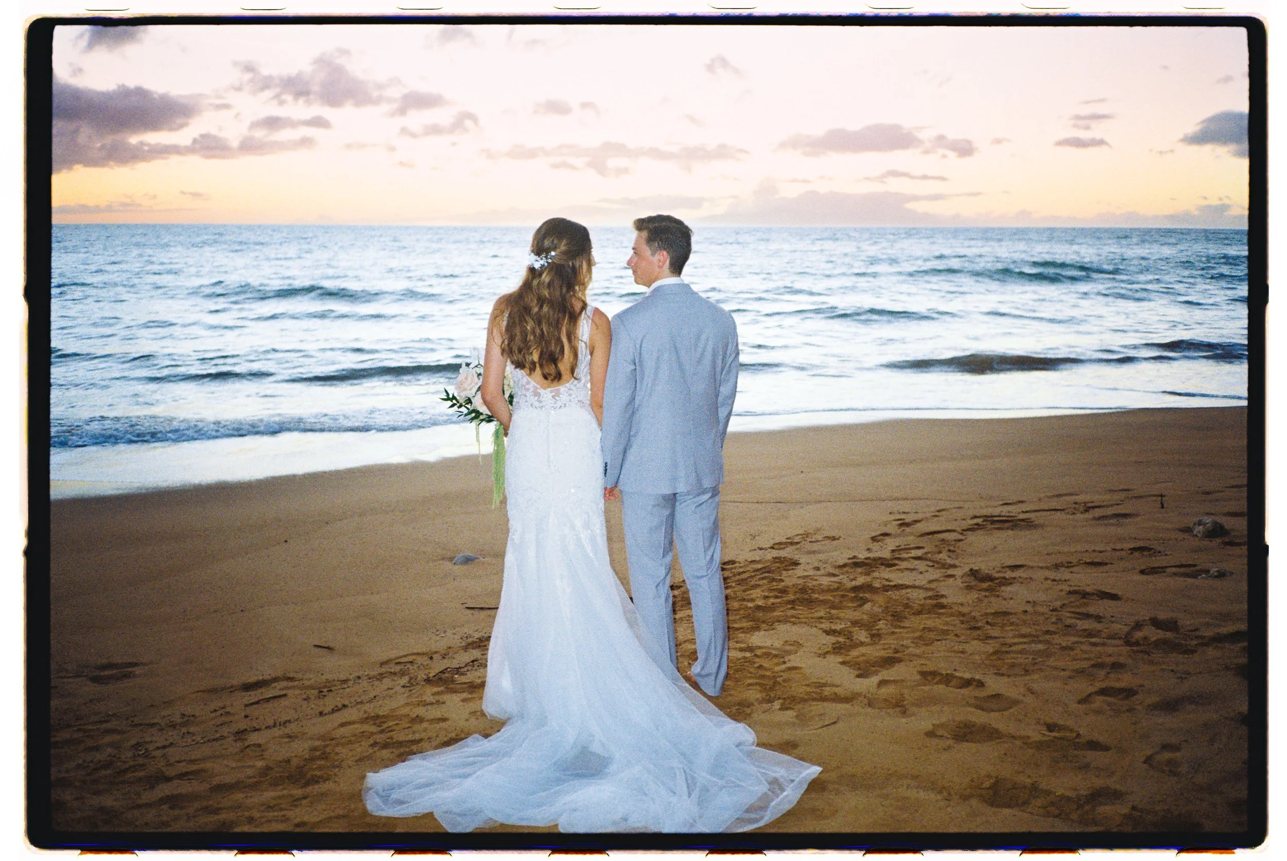 A wedding couple standing on the sand in Wailea Maui at sunset captured using film photography