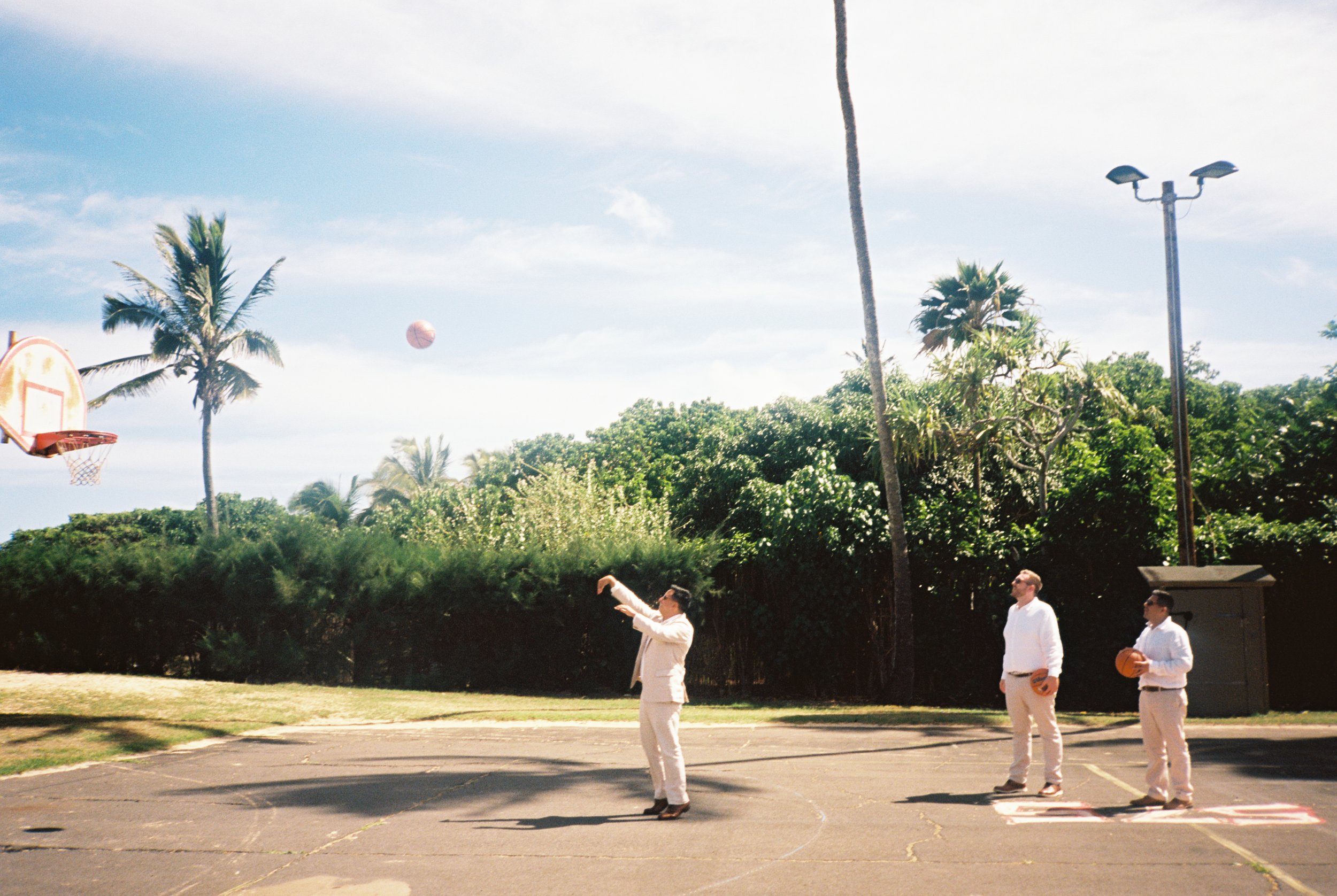 Groom and groomsmen playing basketball before a destination wedding in Maui.