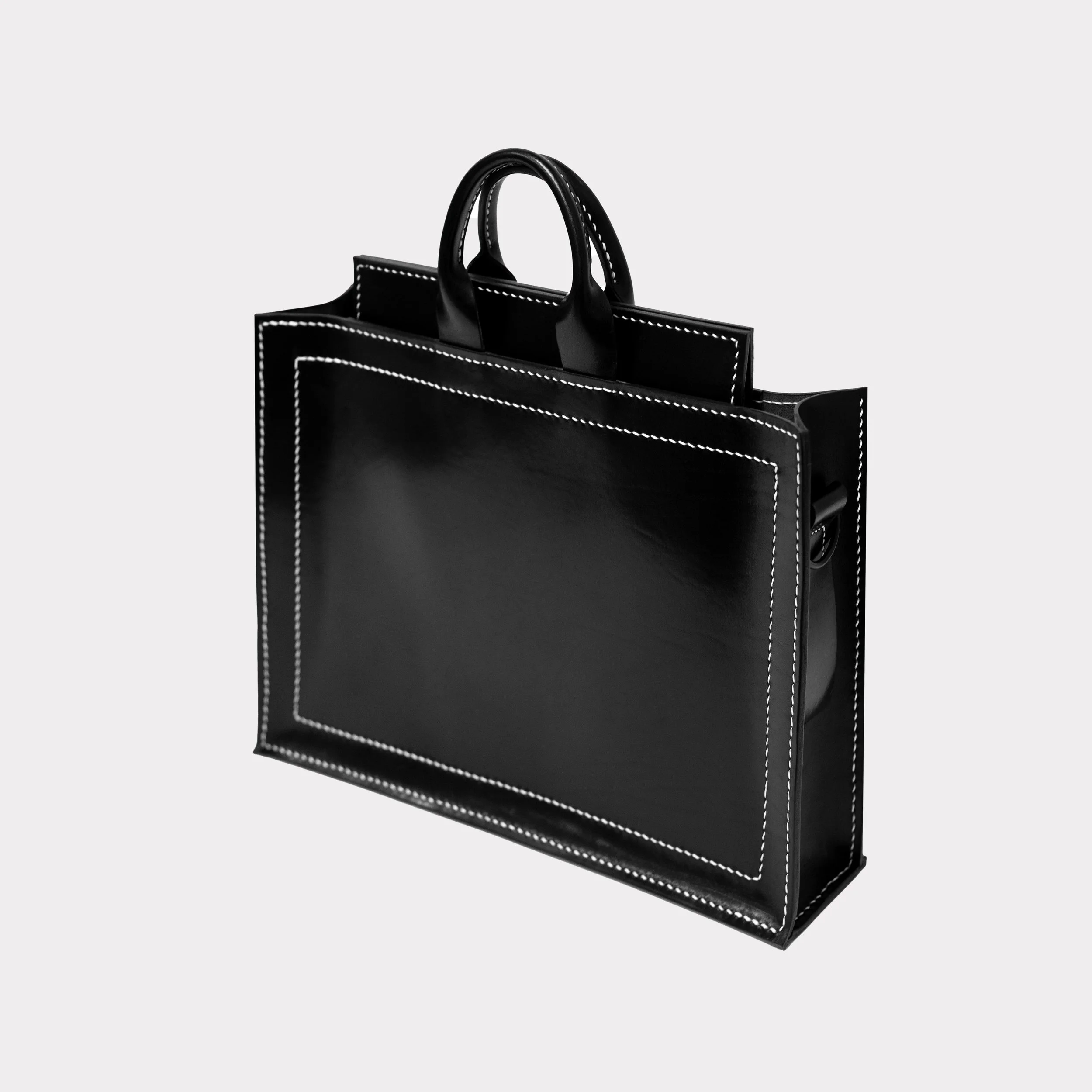 A black handbag with white stitching and a structured rectangular shape.