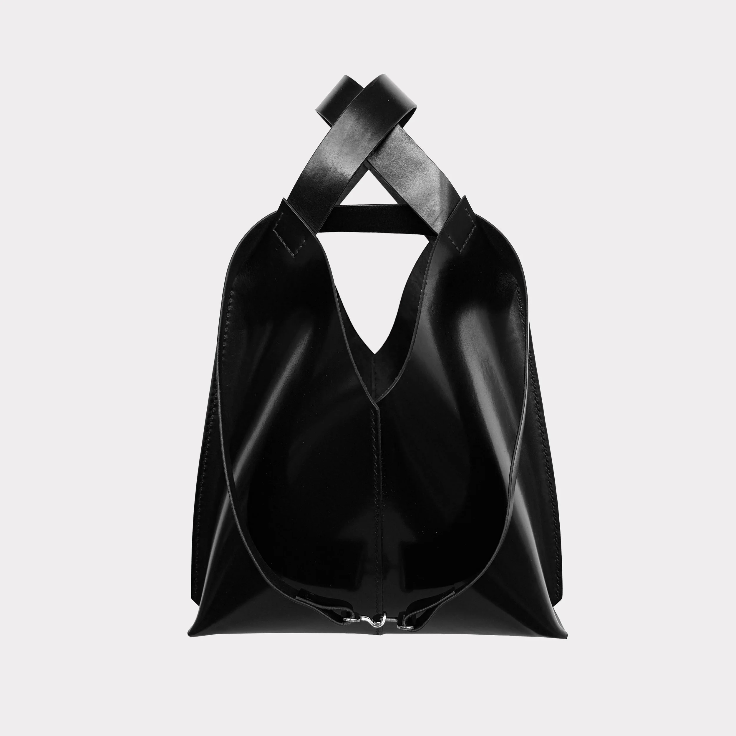 A black leather tote bag with two handles, set against a light gray background.