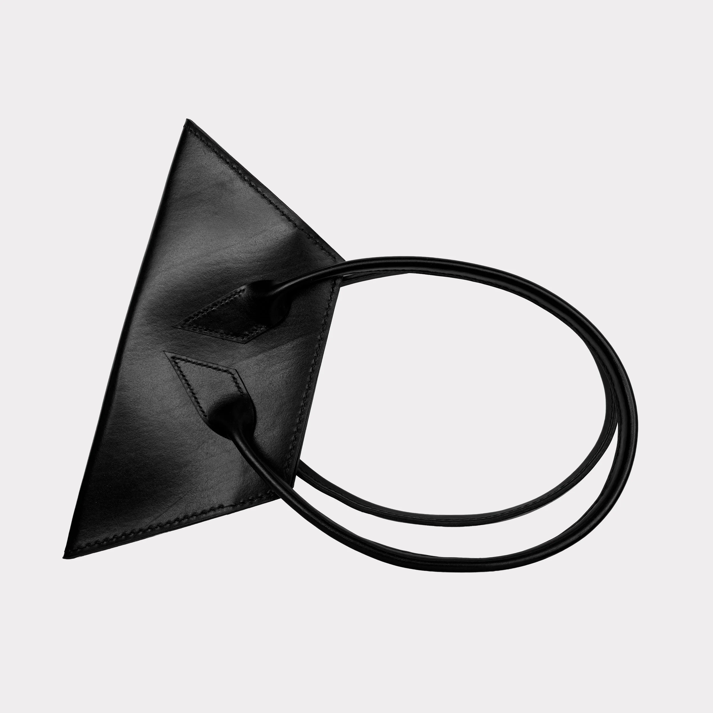 A black leather handbag with a geometric shape on a white background.