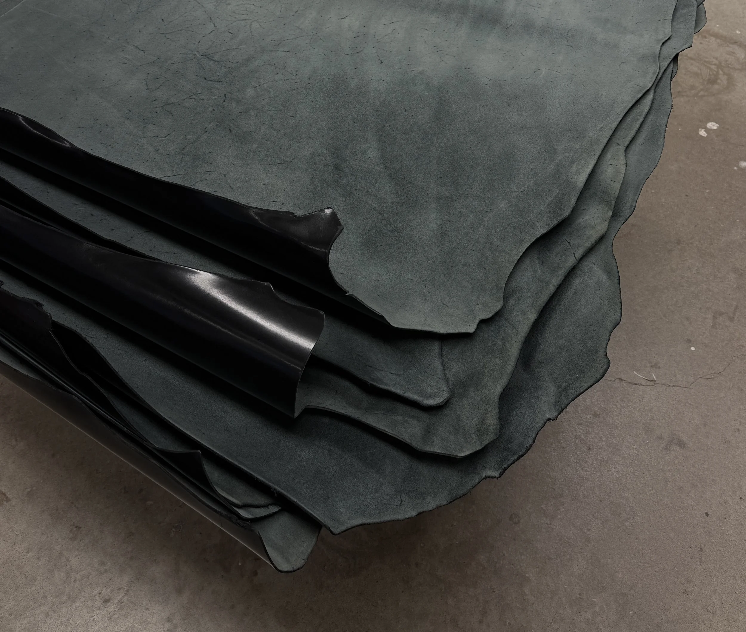 Stack of black leather hides.
