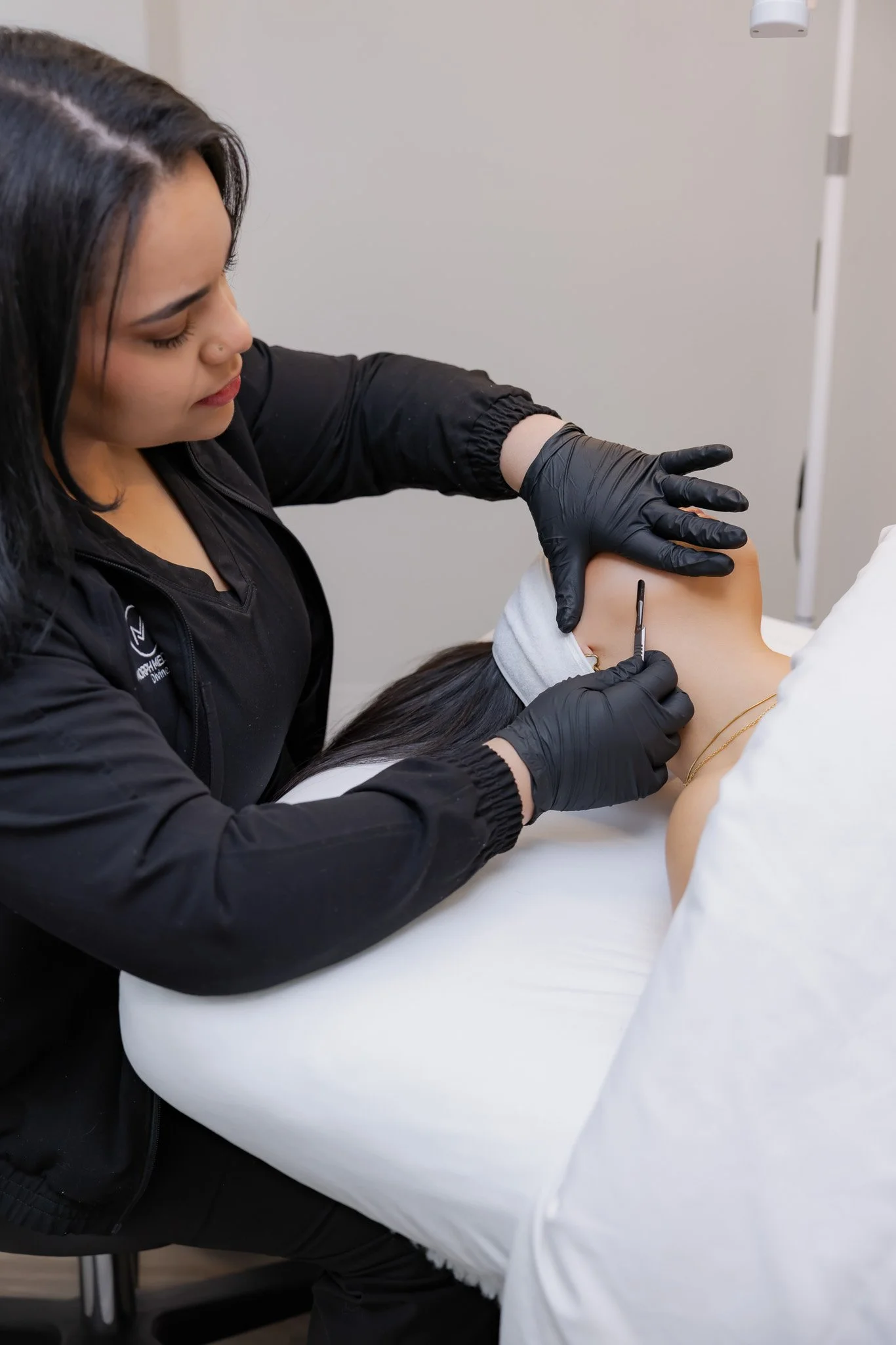 Esthetician performing a dermaplaning treatment on a client's neck at Morph Med Spa in Ridgefield, CT