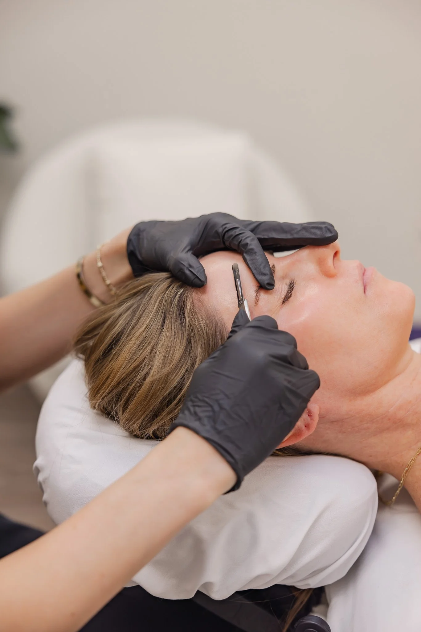 Esthetician performing dermaplaning facial treatment with surgical scalpel at Morph Med Spa in Ridgefield, CT