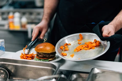 A chef preparing to assemble a burger