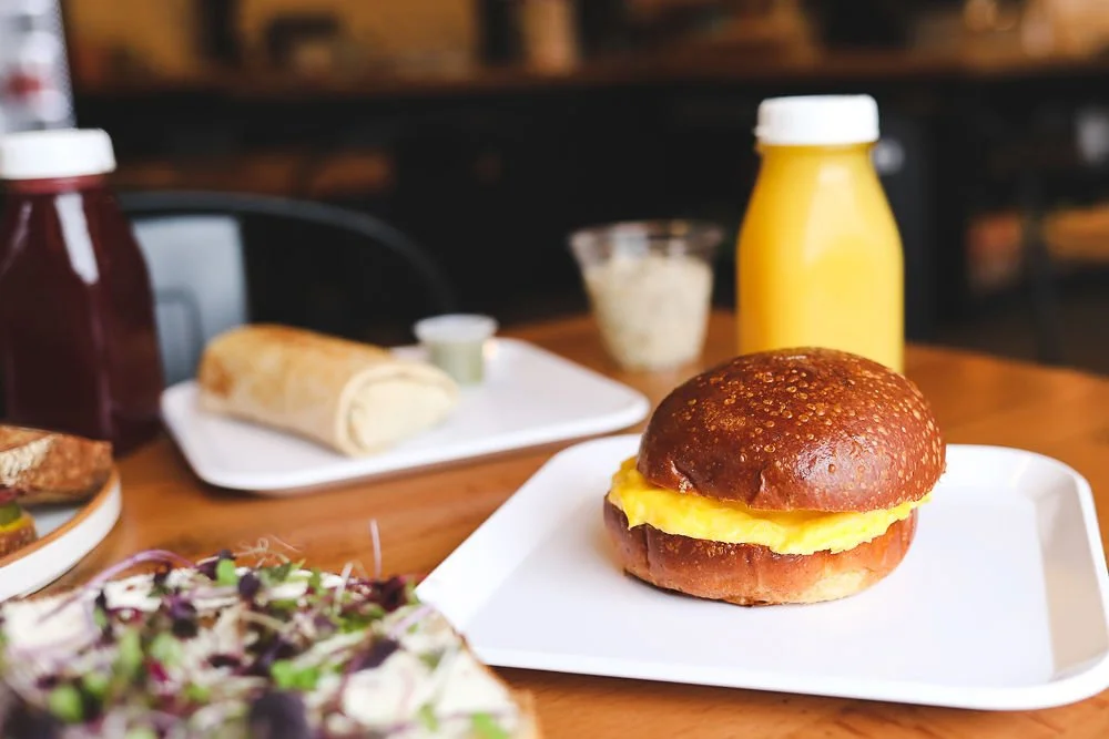 Breakfast burrito and egg sandwich with fresh squeezed juice and overnight oats