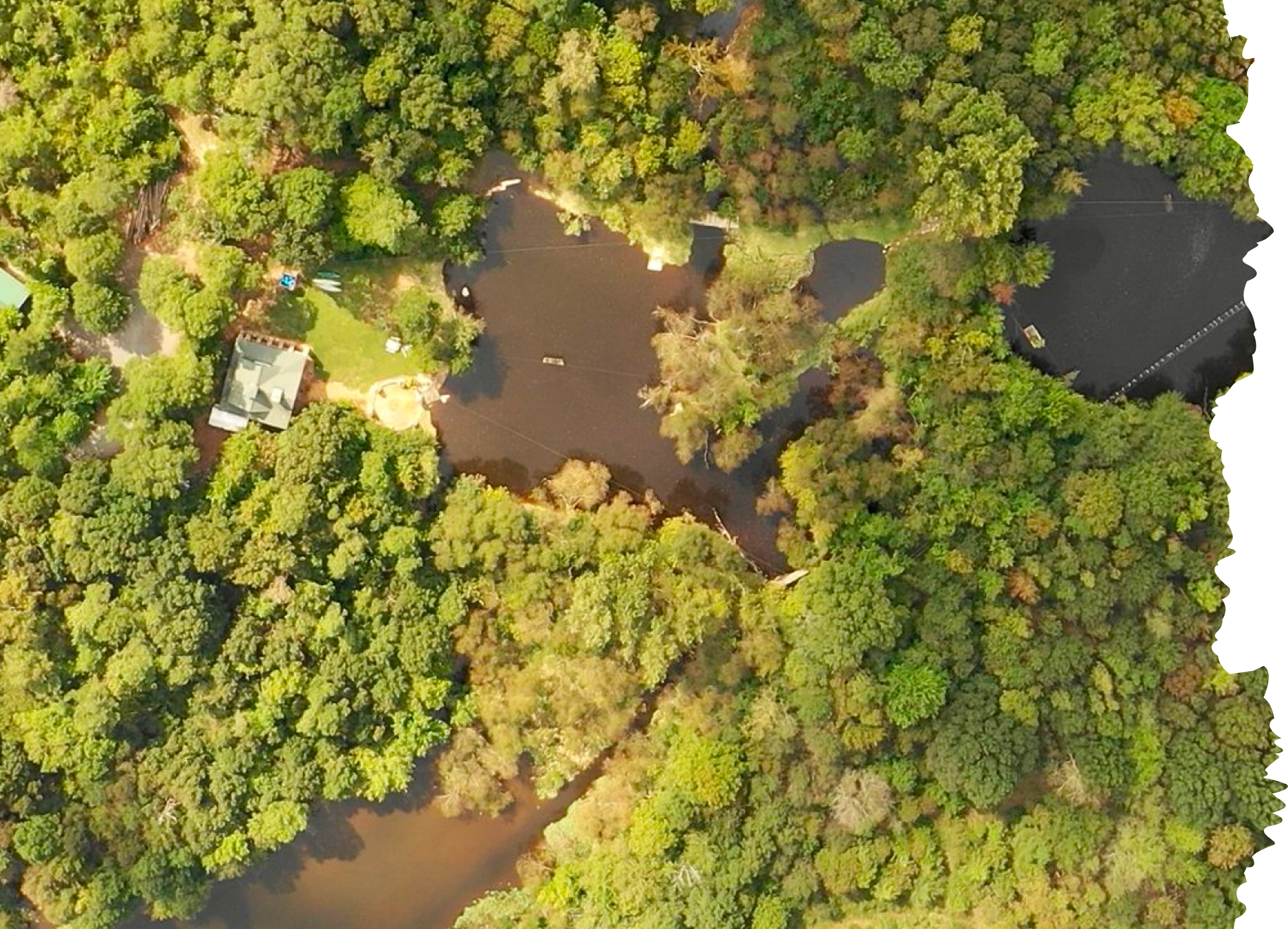 Aerial view of Xtreeme Challenge's 17-acre property with lake, lodge and wooded trails
