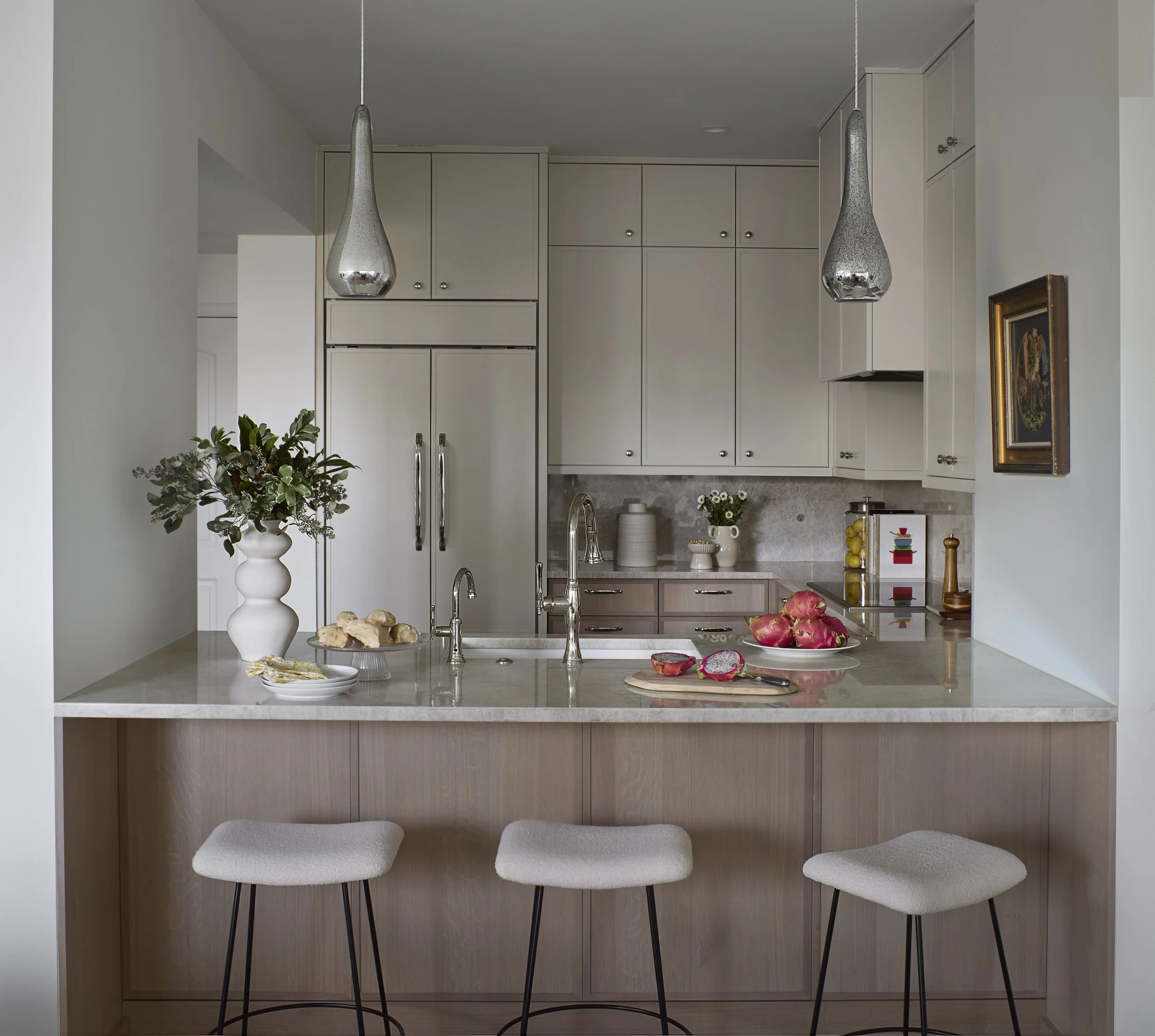 Custom kitchen island designed by Flemming Interiors for a full condo renovation in Cherry Creek, Colorado, featuring integrated storage, stone countertops, and tailored millwork.