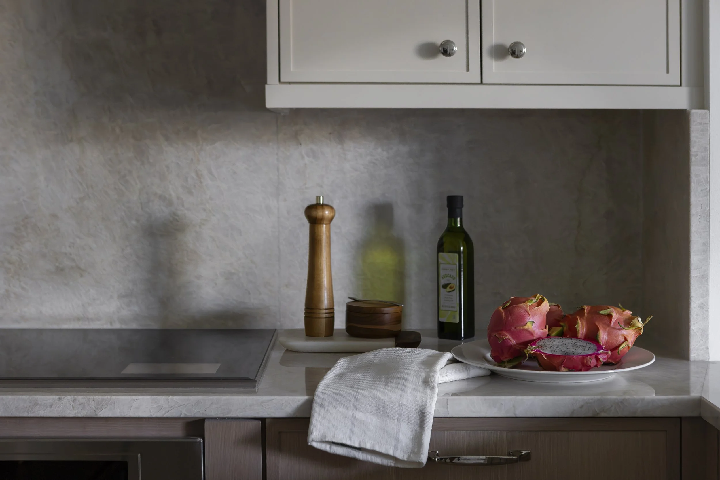 Kitchen countertop detail designed by Flemming Interiors in a Cherry Creek condo renovation, featuring stone surfaces, integrated cooktop, and thoughtfully styled accessories.