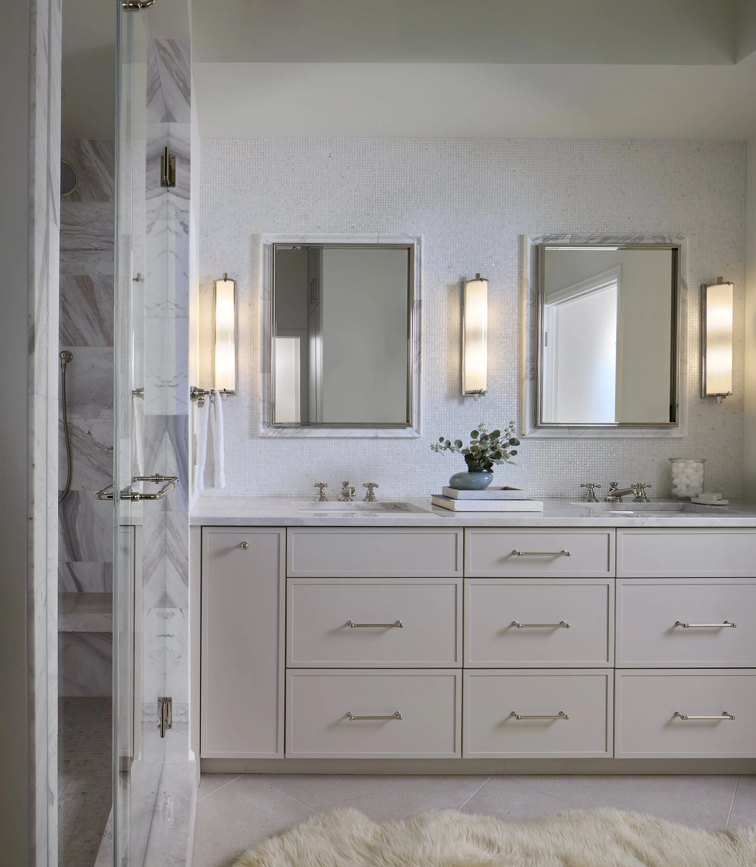 Primary bathroom designed by Flemming Interiors as part of a full condo renovation in Cherry Creek, Colorado, featuring a custom double vanity, stone surfaces, and integrated shower detailing.